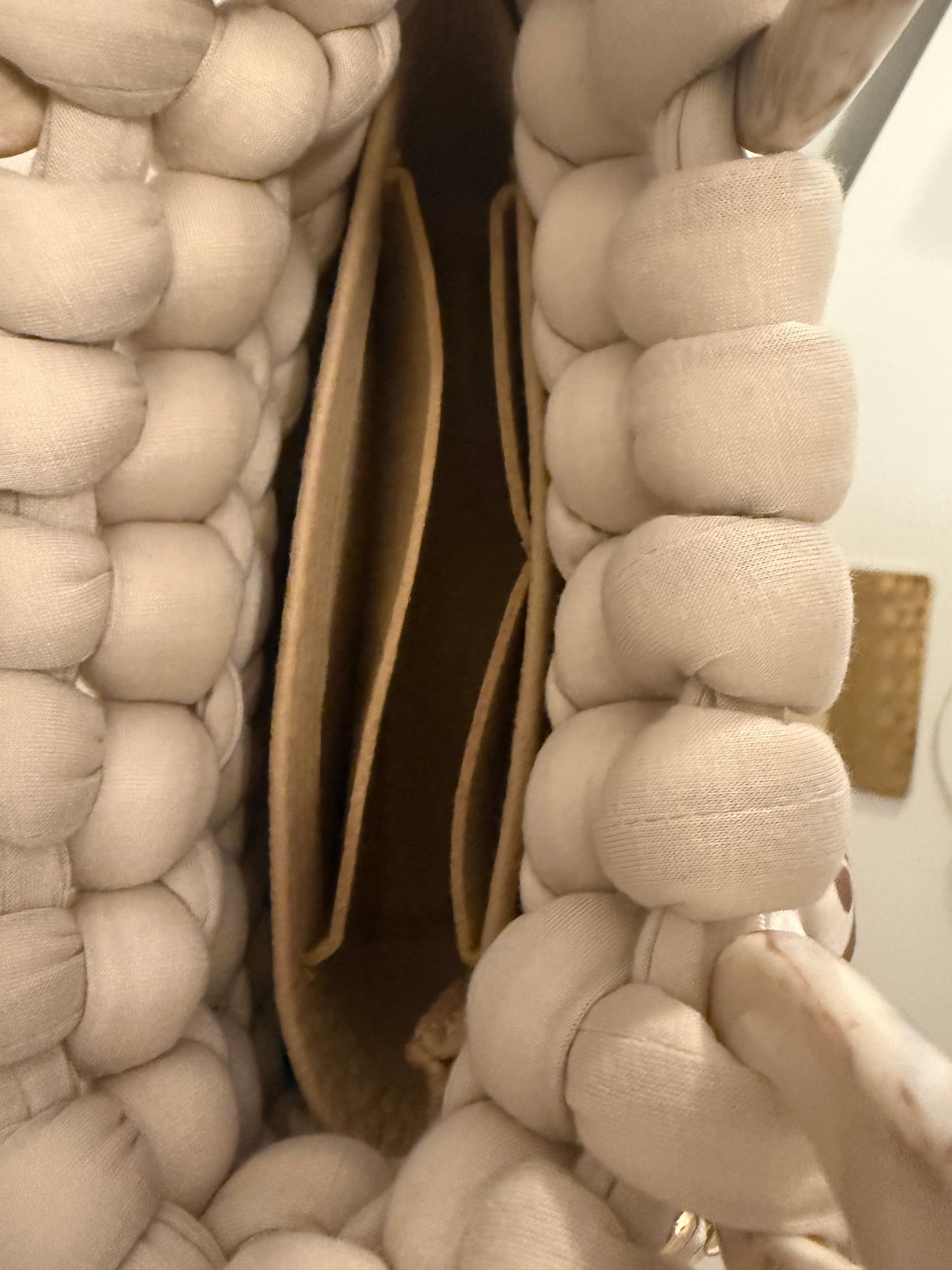 Interior view of Latte cream chunky bubble braid bag showing warm caramel inner liner and structured base