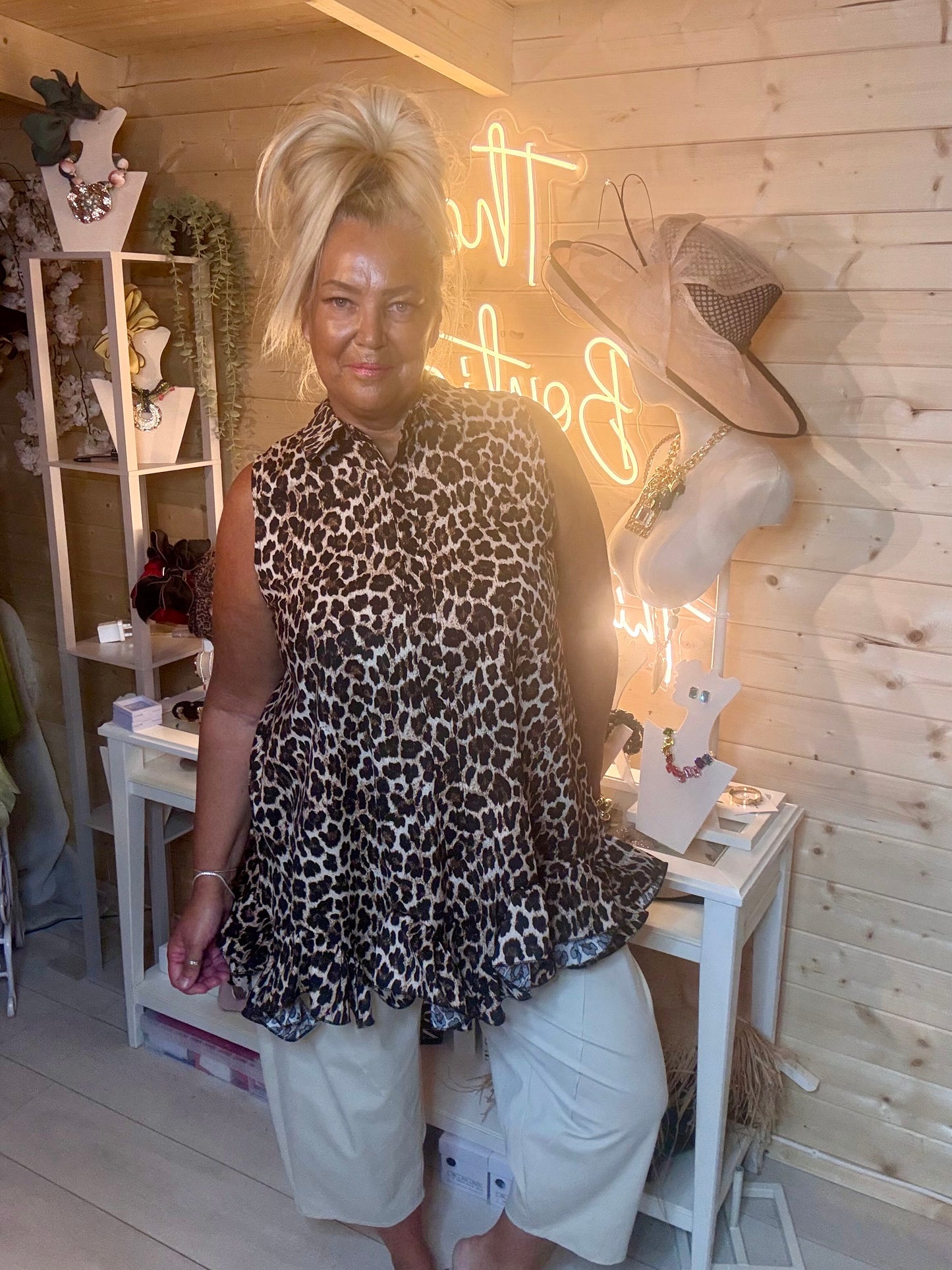 Leopard print swing tunic – full length boutique shot showing floaty tiered ruffle hem and relaxed silhouette styled with white shorts in boutique setting