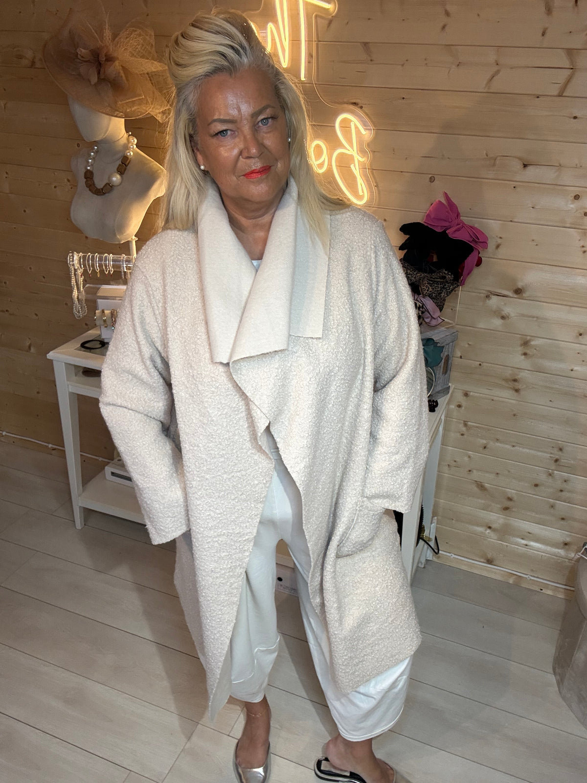 Marlow Stone Shimmer Waterfall Coat – full length boutique mirror shot, styled with cream trousers and silver mules
