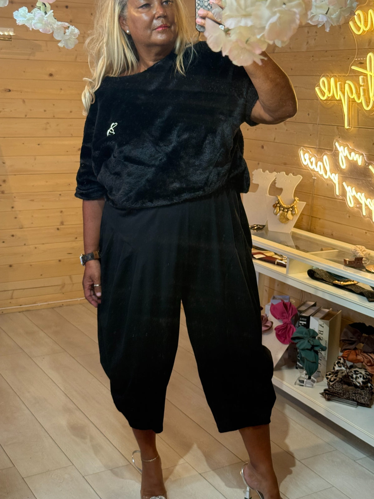 Black Orla faux fur top with short sleeves paired with black slouch trousers