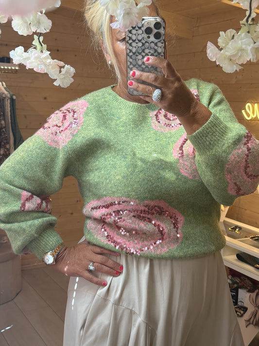 Close-up of pink sequin rose designs on the sage green Rosella knit jumper
