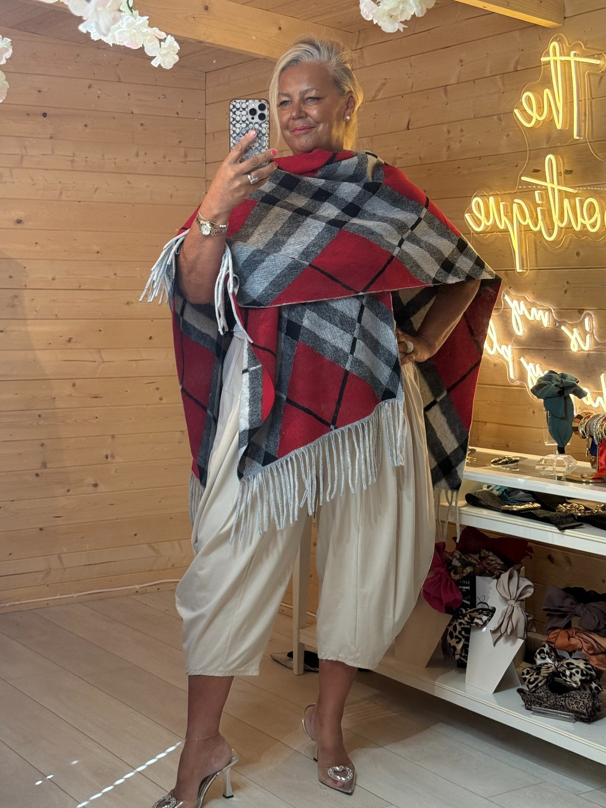 Roxie red and charcoal plaid cape worn over the shoulders showing fringe hem