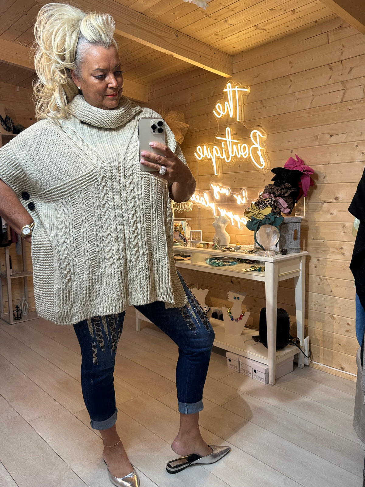 Portofino Cream Cable Knit Poncho – three-quarter mirror shot showing relaxed poncho silhouette and open side slits with dark jeans