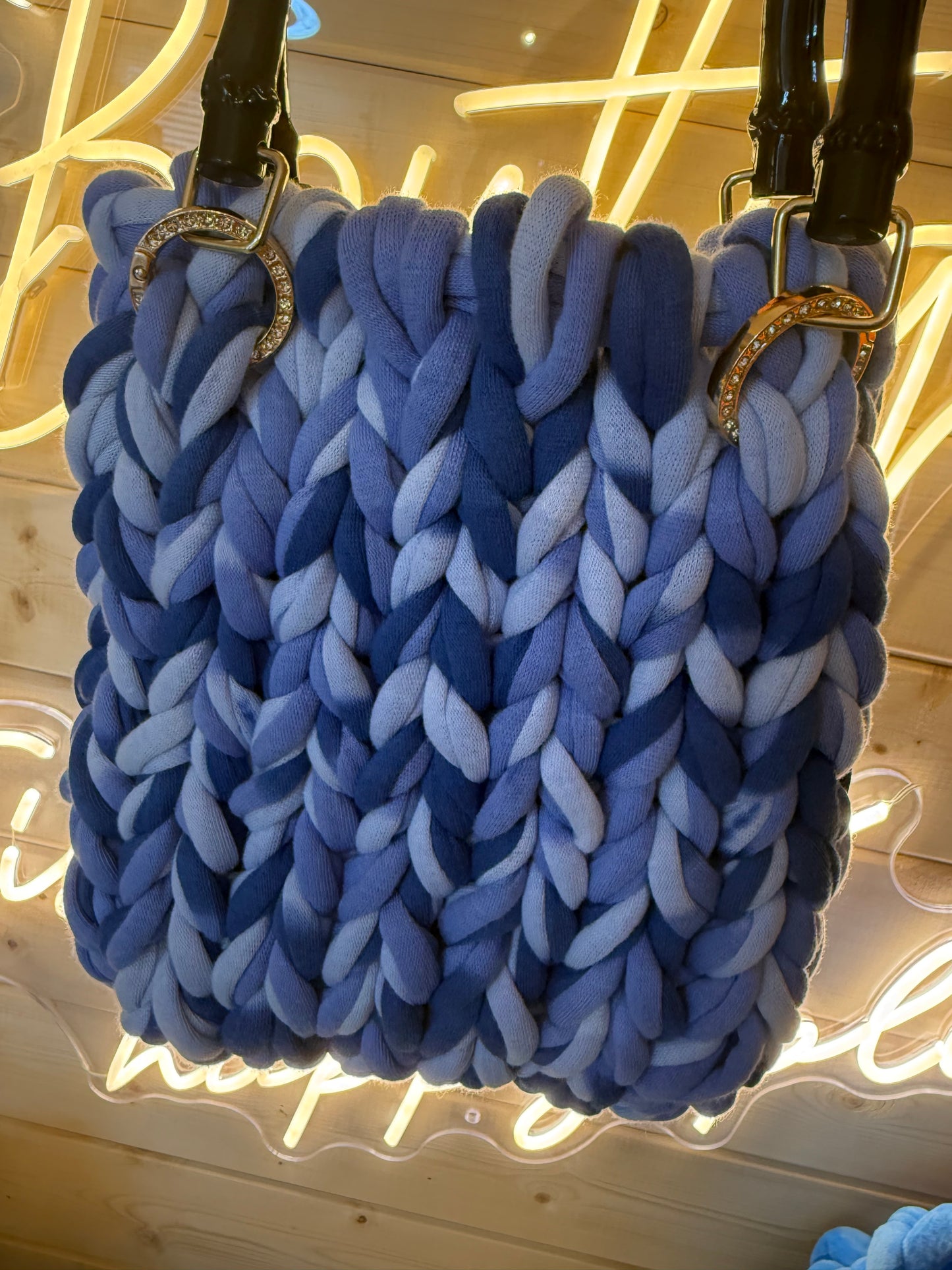 Azure ombré chunky knit bamboo tote bag held showing bamboo handles and diamanté rings