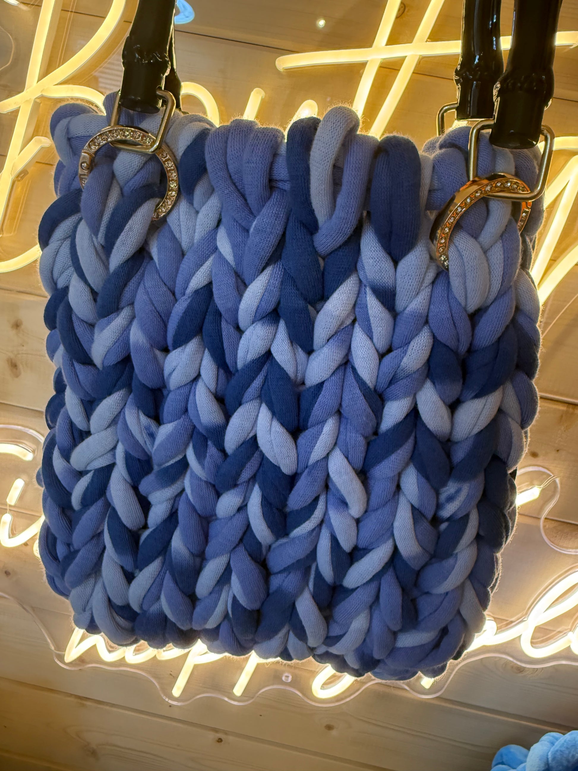 Azure ombré chunky knit bamboo tote bag held showing bamboo handles and diamanté rings