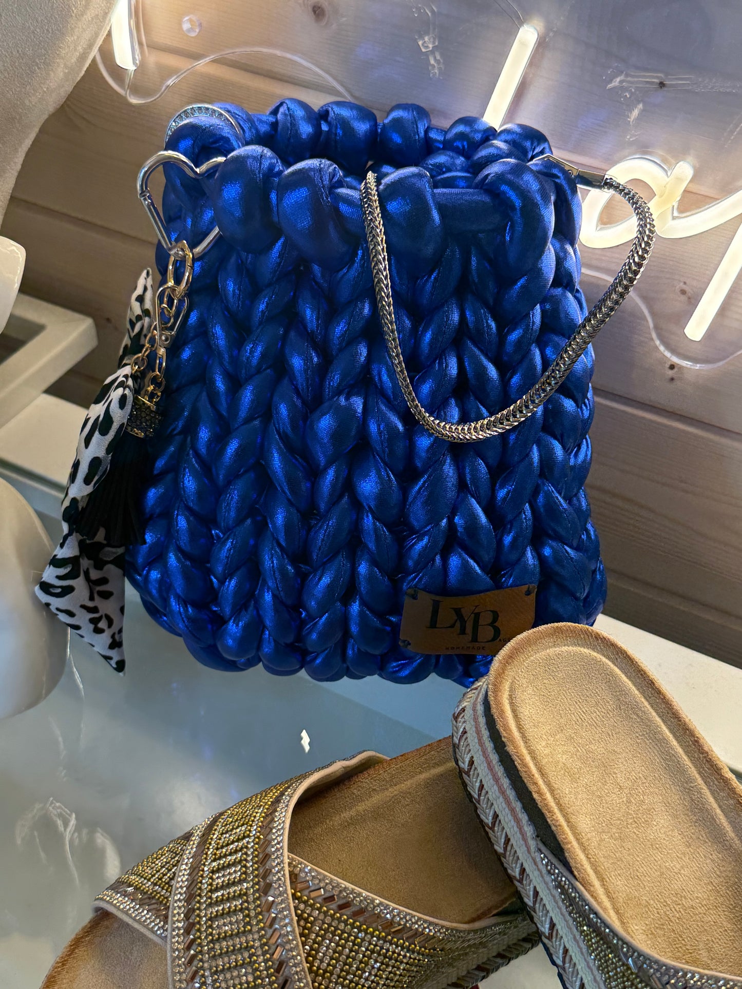 Cobalt blue metallic chunky braid bucket bag front view showing vivid blue braid texture and silver chain strap
