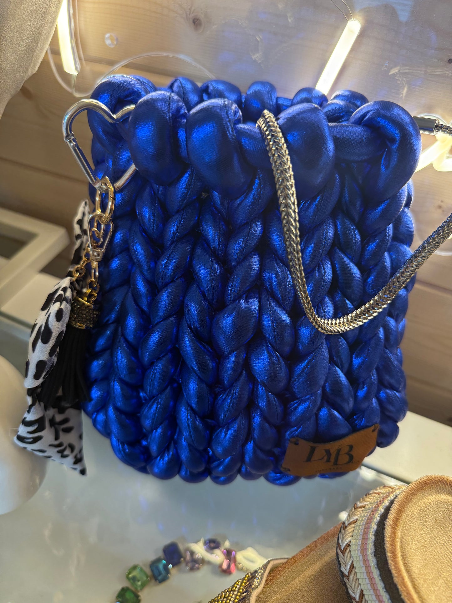Cobalt blue metallic chunky braid bucket bag side view with dalmatian print scarf and black tassel charm