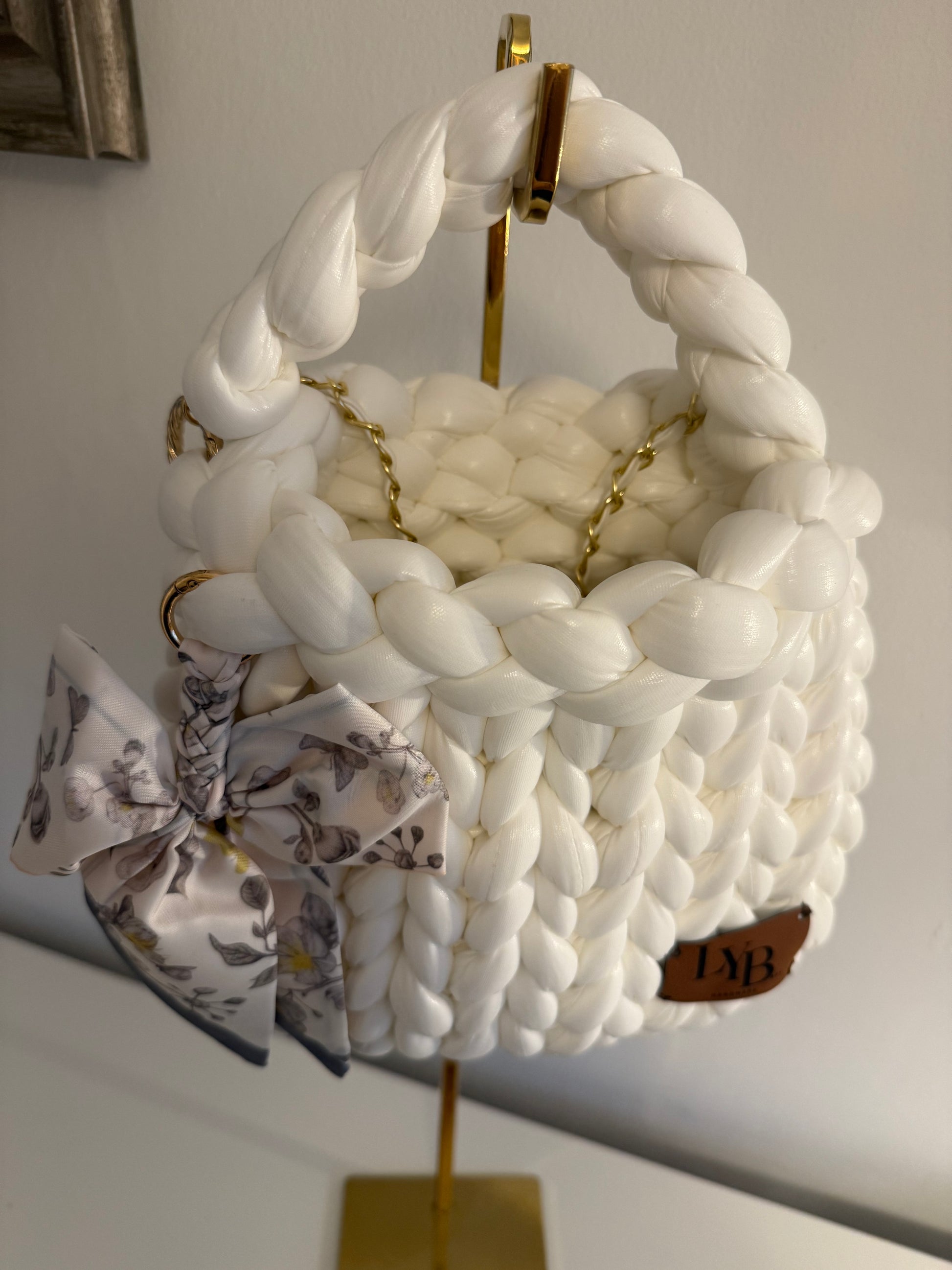 Close-up of floral bow detail on Arctic white chunky braided bag with gold ring