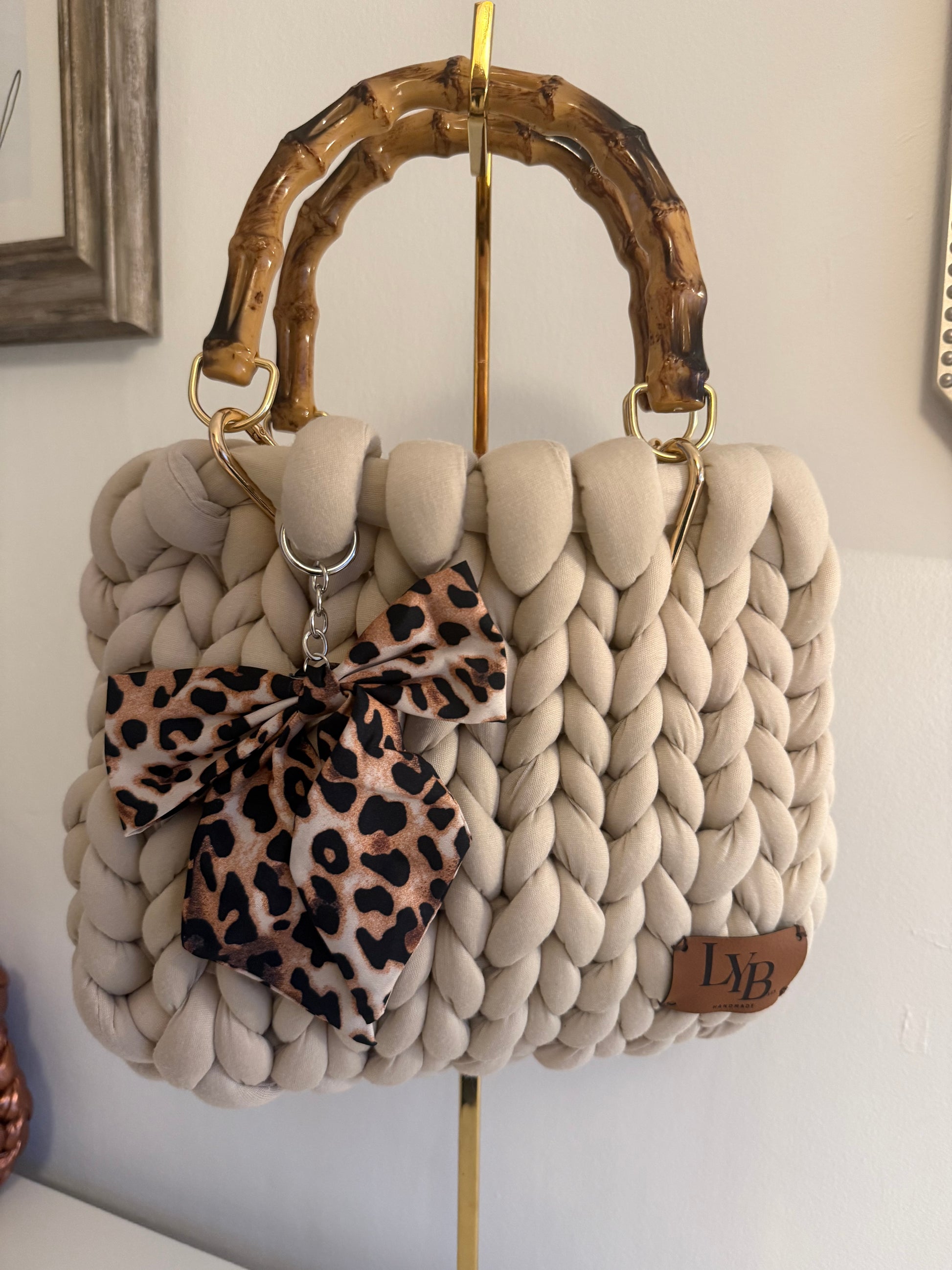 Pippa cream chunky braid bag with lacquered bamboo handle and leopard print bow charm - front view
