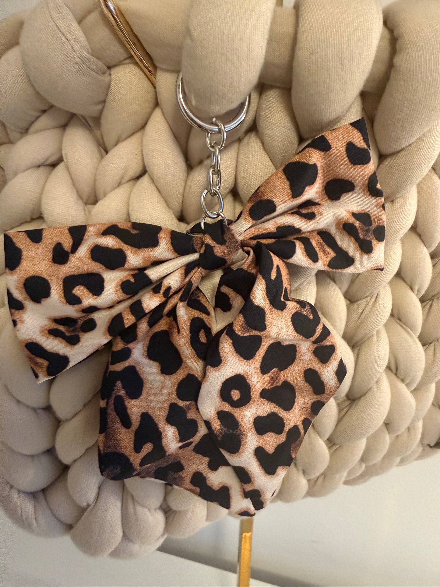 Close-up of detachable leopard print satin bow charm on silver keyring on Pippa cream braid bag