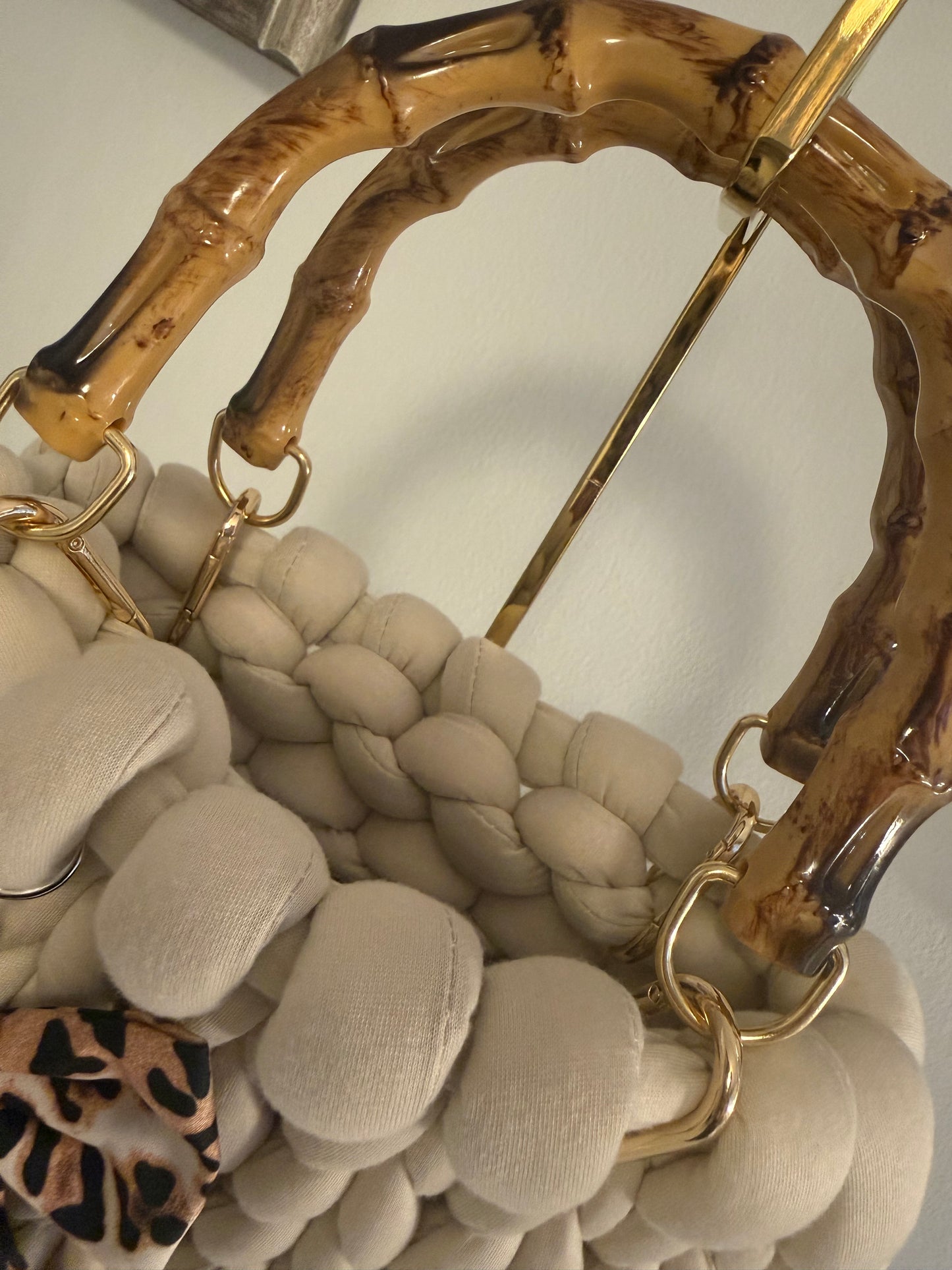 Close-up of lacquered bamboo top handle with gold-tone ring hardware on Pippa chunky braid bag