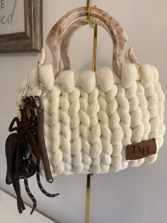 Pola cream chunky knit bag with marbled acrylic handle and dark charm cluster - front view
