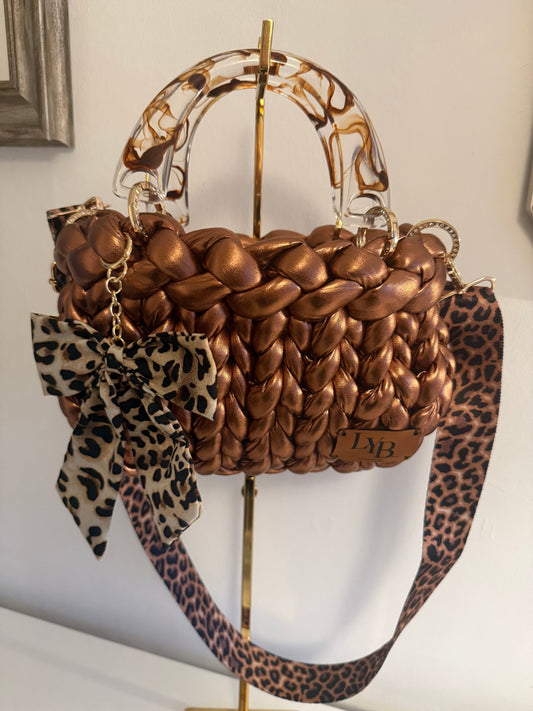 Rustica metallic bronze chunky braid bag with marbled acrylic handle, leopard bow and crossbody strap - front view