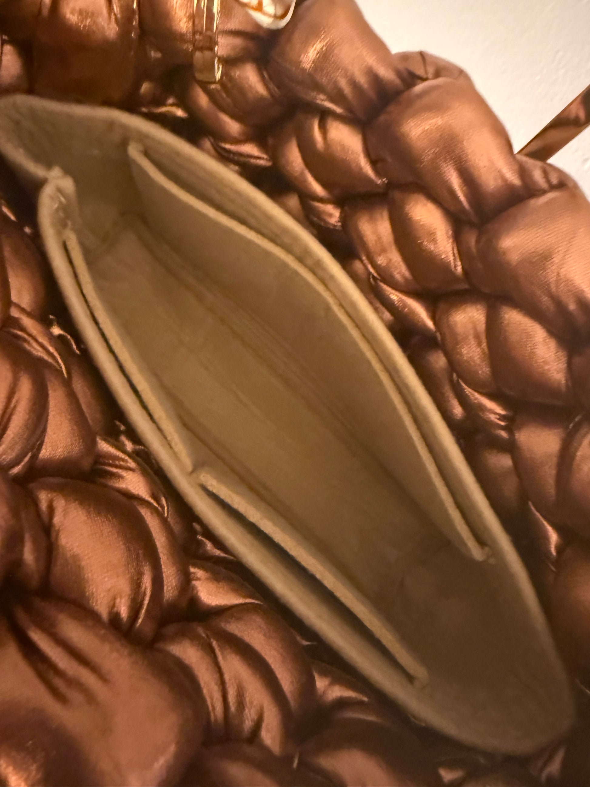 Interior view of Rustica bronze chunky braid bag showing smooth caramel-toned lining and structured base