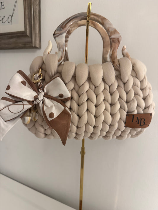 Latte cream chunky bubble braid bag with marbled acrylic handle, polka dot bow charm and LYB leather patch - front view