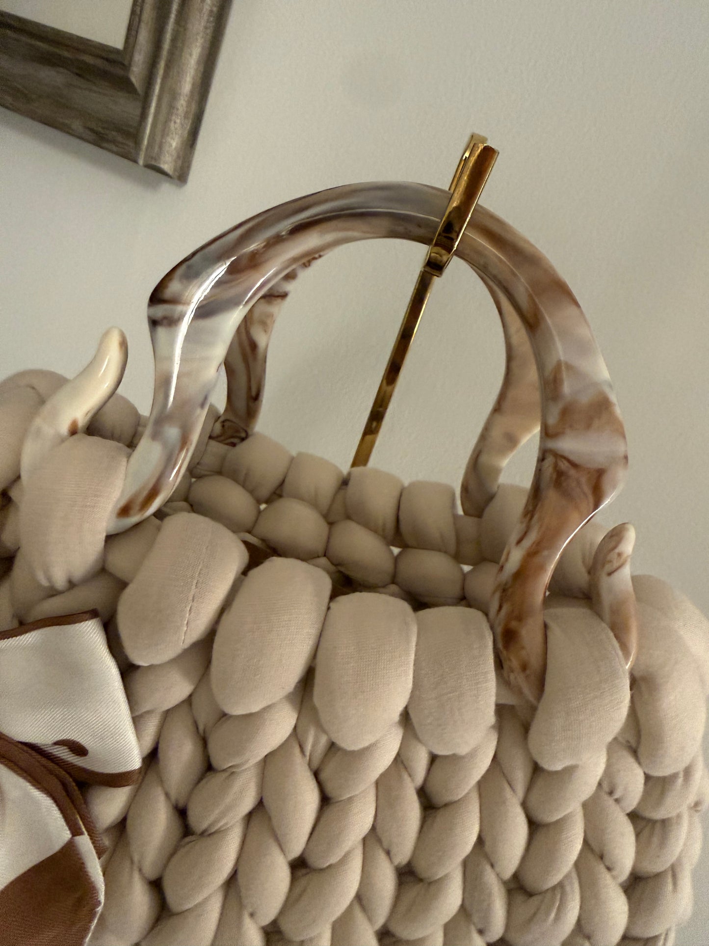 Close-up of marbled acrylic top handle on Latte cream chunky bubble braid luxury handbag