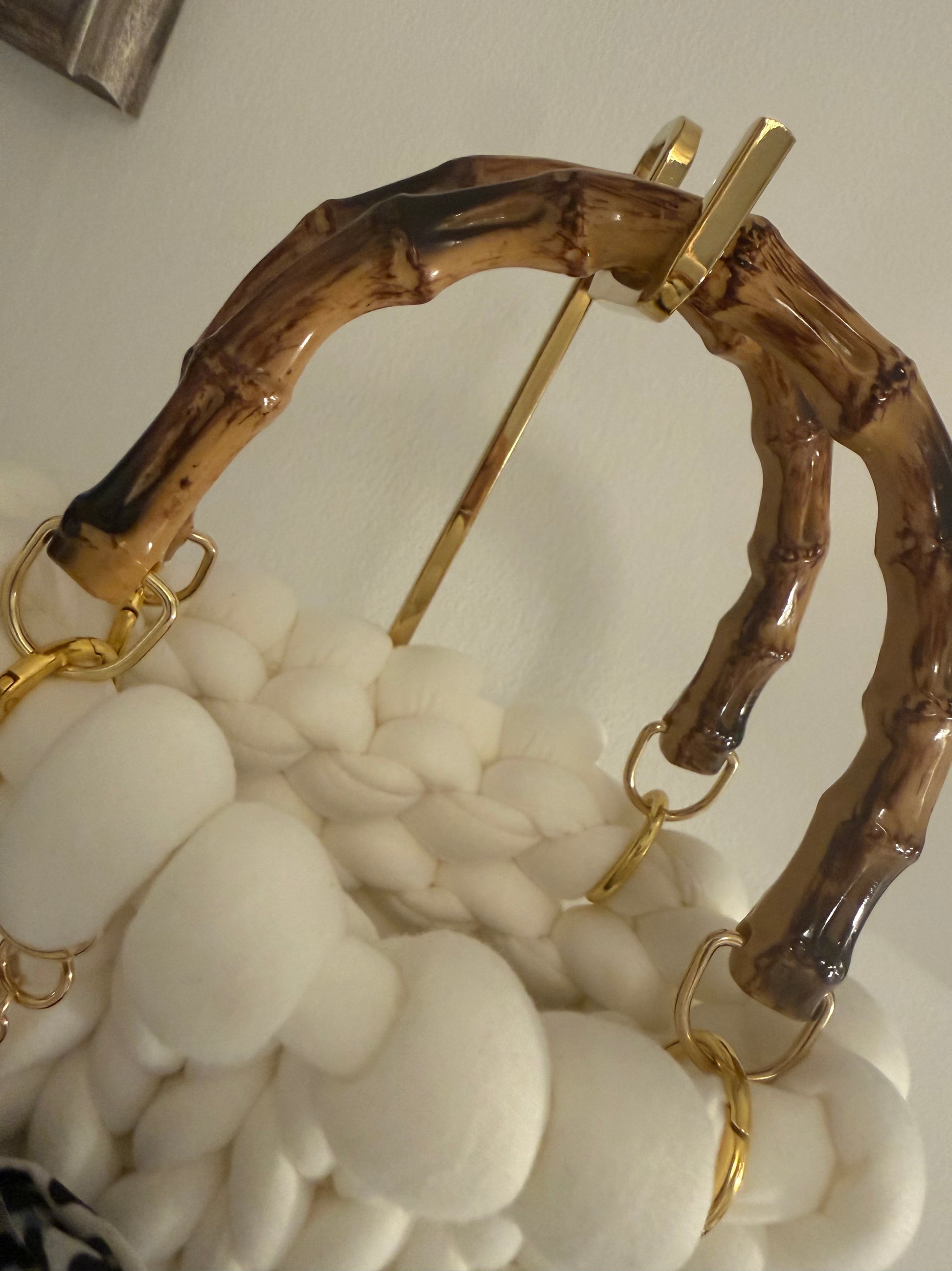 Close-up of lacquered bamboo top handle with gold-tone ring hardware on Blanca chunky bubble braid bag
