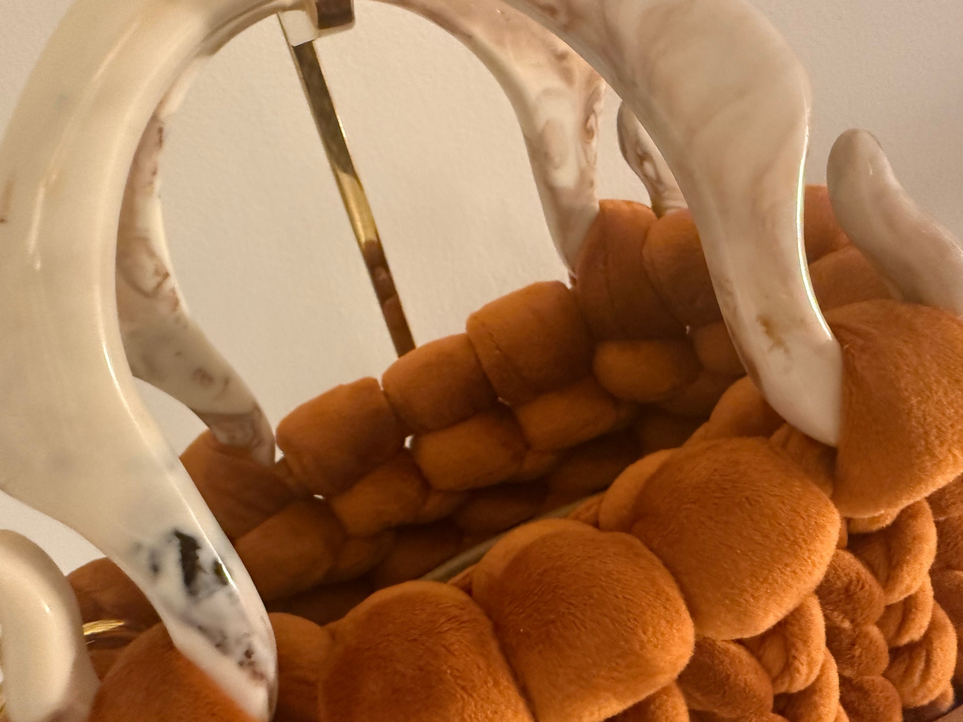 Close-up of marbled white acrylic top handle on Autumn Lust burnt orange velvet chunky braid bag