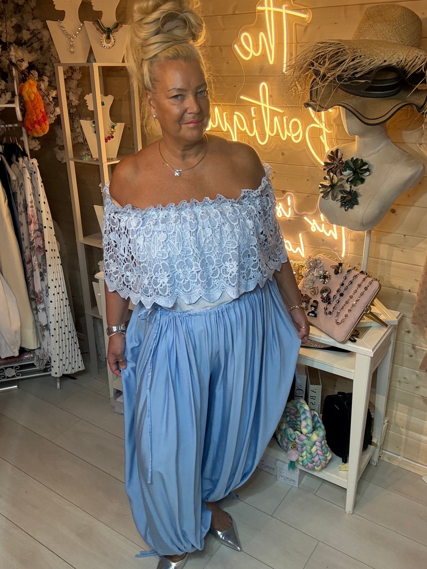 Azure lace bardot top with scalloped hem styled with baby blue harem trousers – side angle