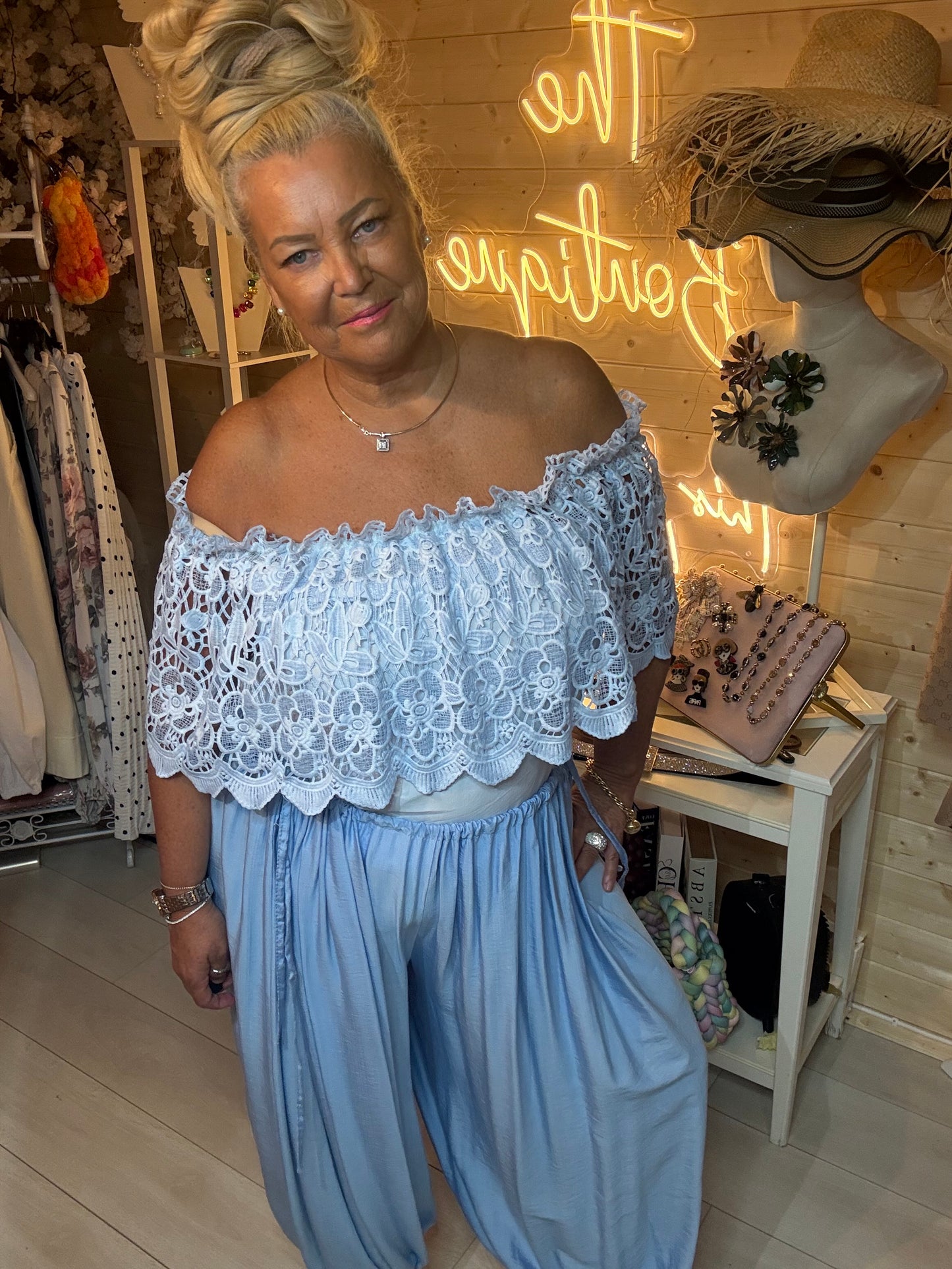 Woman wearing Azure baby blue lace bardot crop top with matching harem trousers – front view boutique