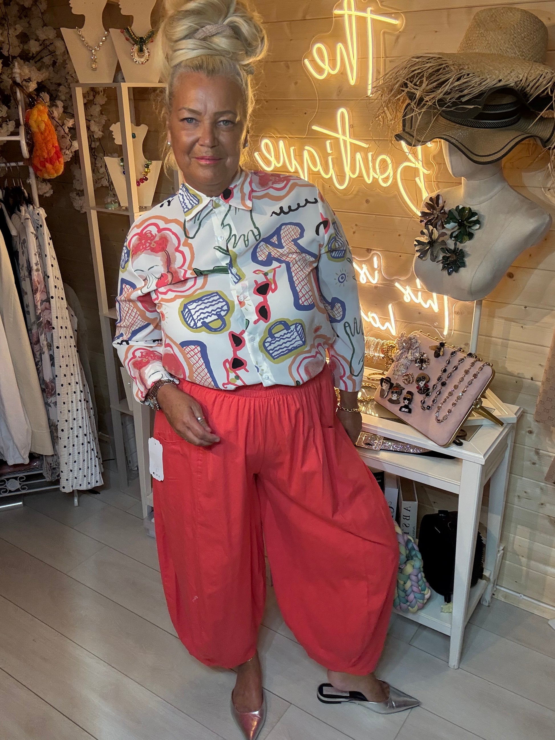 Woman wearing Sketch fashion illustration print blouse with coral harem trousers – full length boutique front view