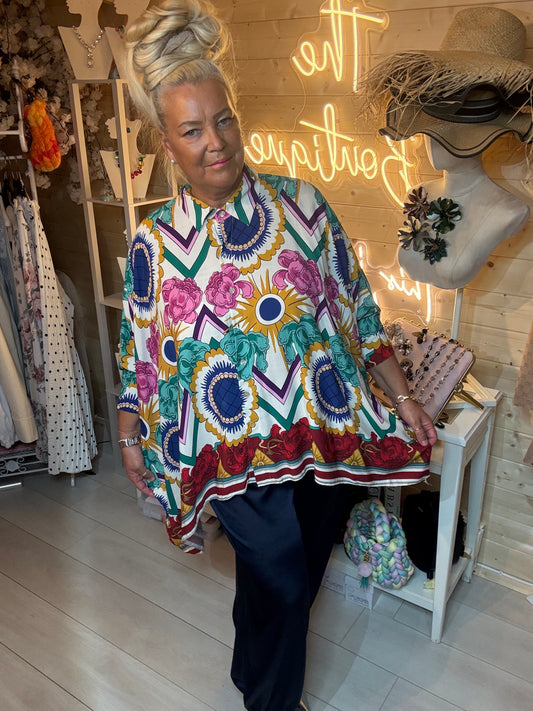 Woman wearing Baroque bold floral chevron print oversized shirt with navy harem trousers – boutique front view