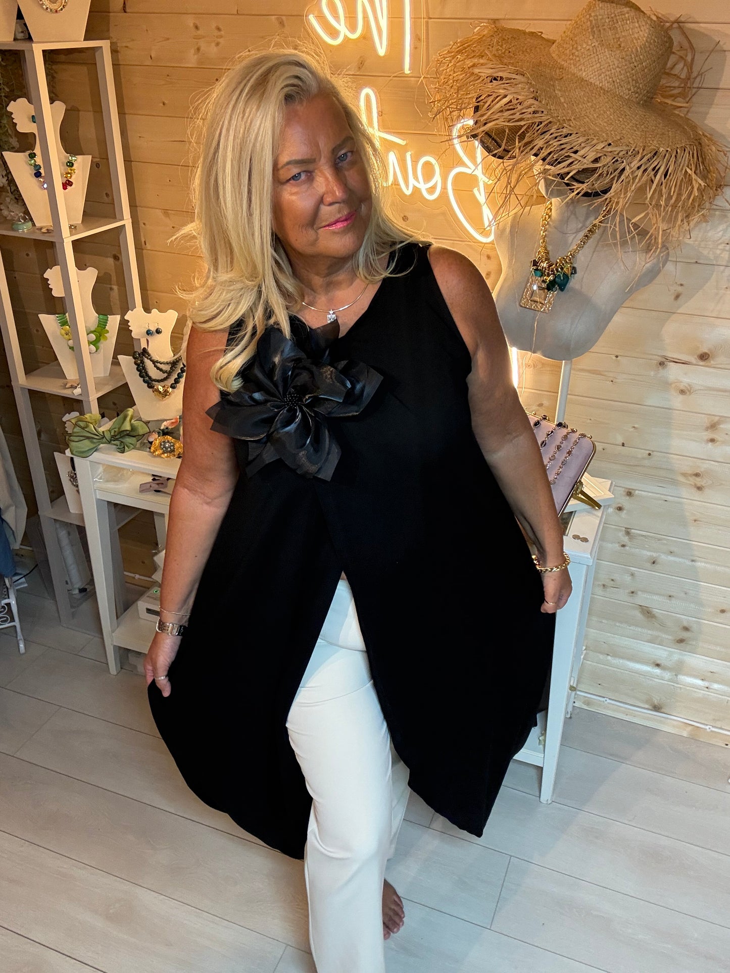 Fleur Asymmetric Wrap Slit Tunic Top with Detachable Black Satin Flower Corsage in Black - front view - One Size 8-20 - The Ultimate Ladies Boutique