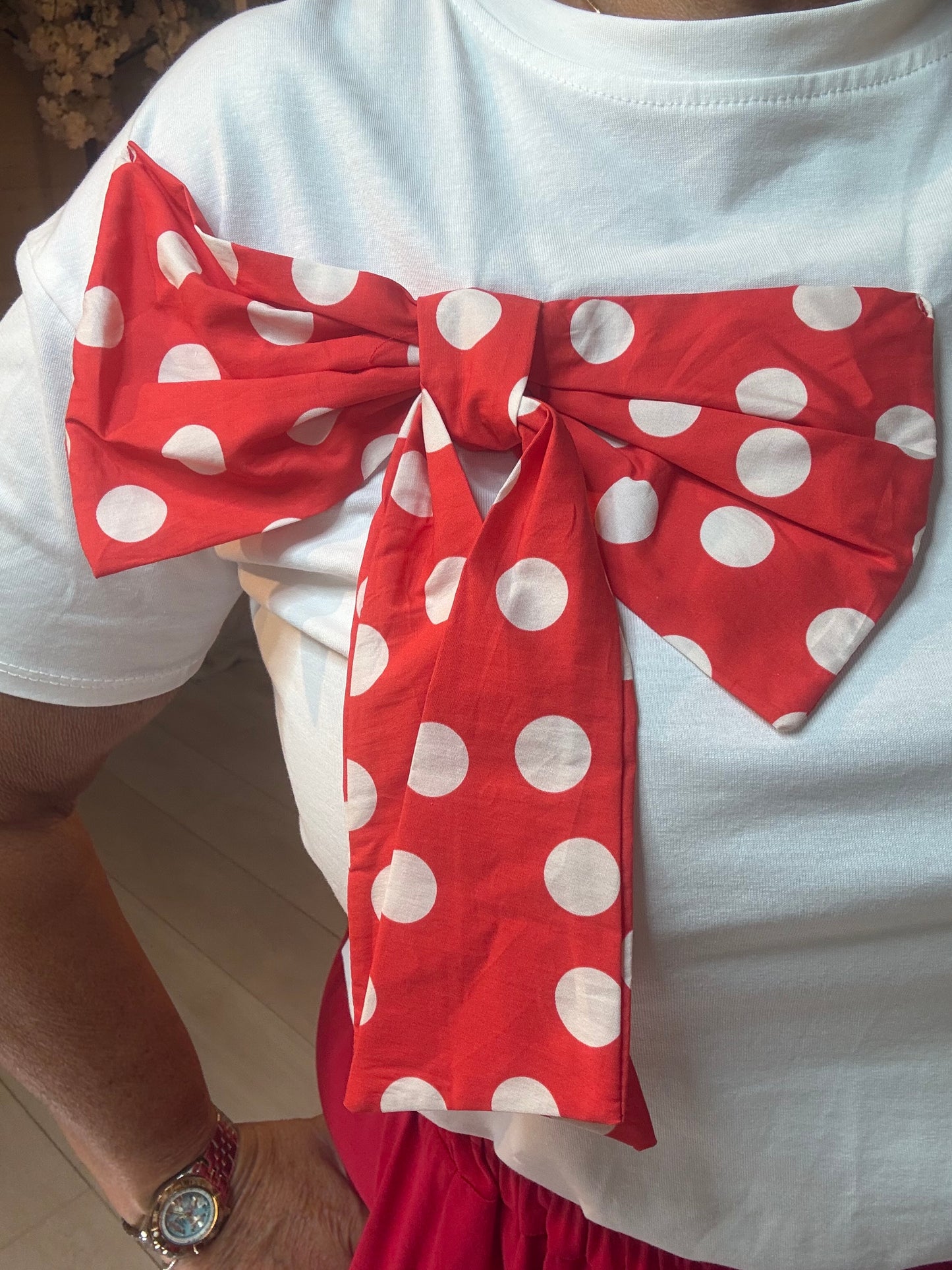 Minnie polka dot bow t-shirt close-up of oversized red and white bow appliqué detail