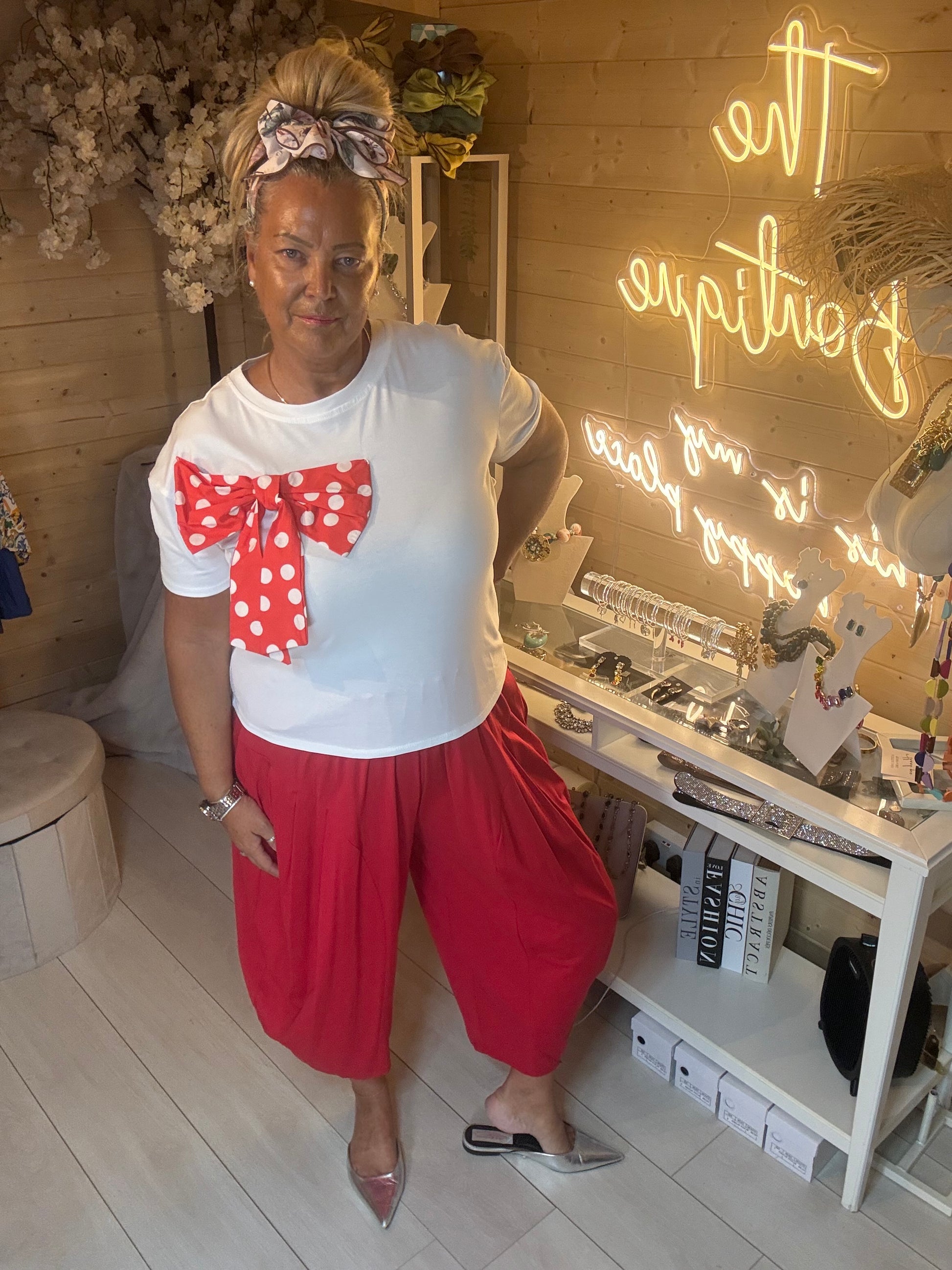Minnie white bow t-shirt front view on model – red polka dot bow appliqué detail boutique top