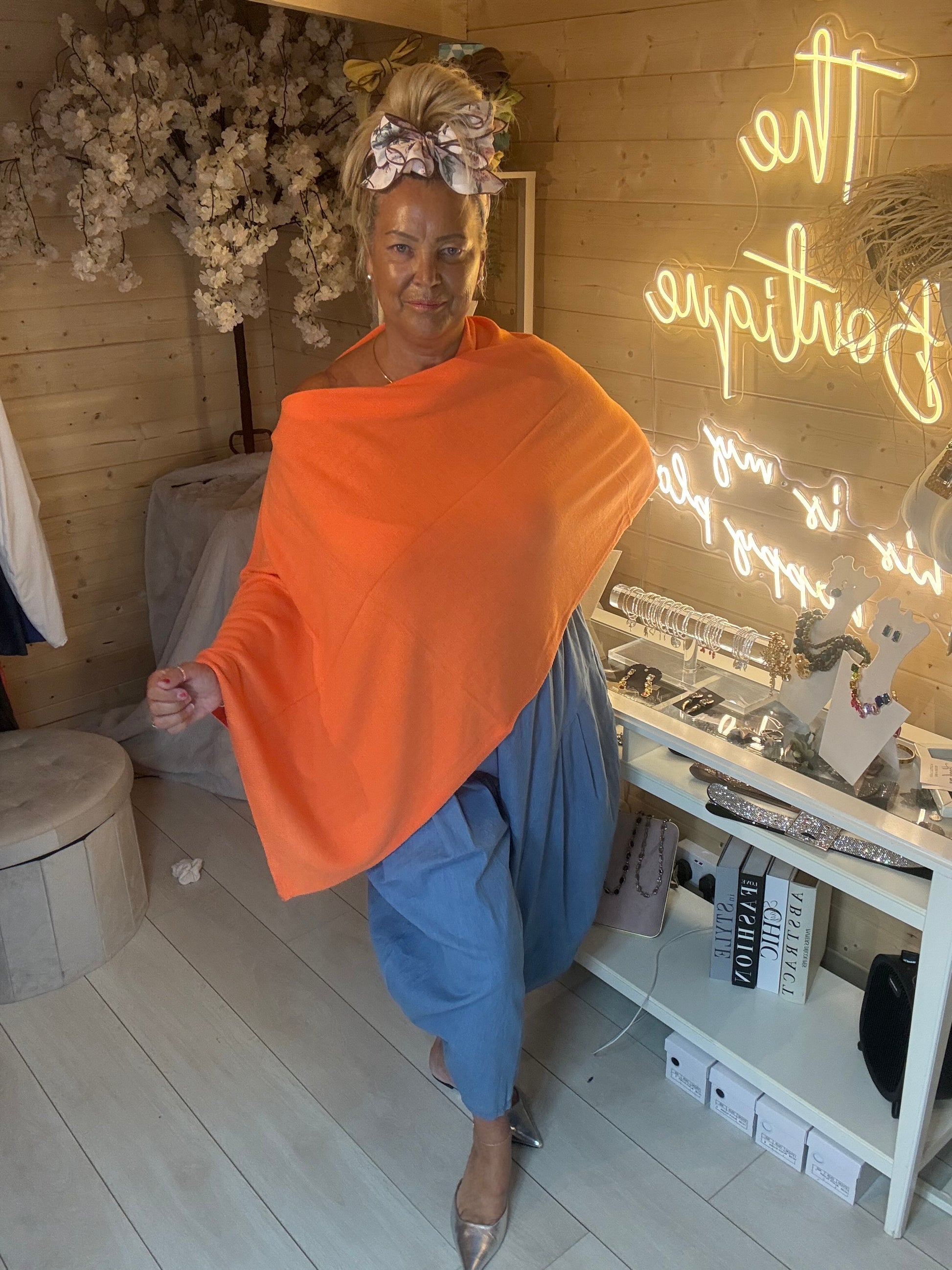 Brezza lime poncho cape front view on model styled with blue harem trousers and silver mules