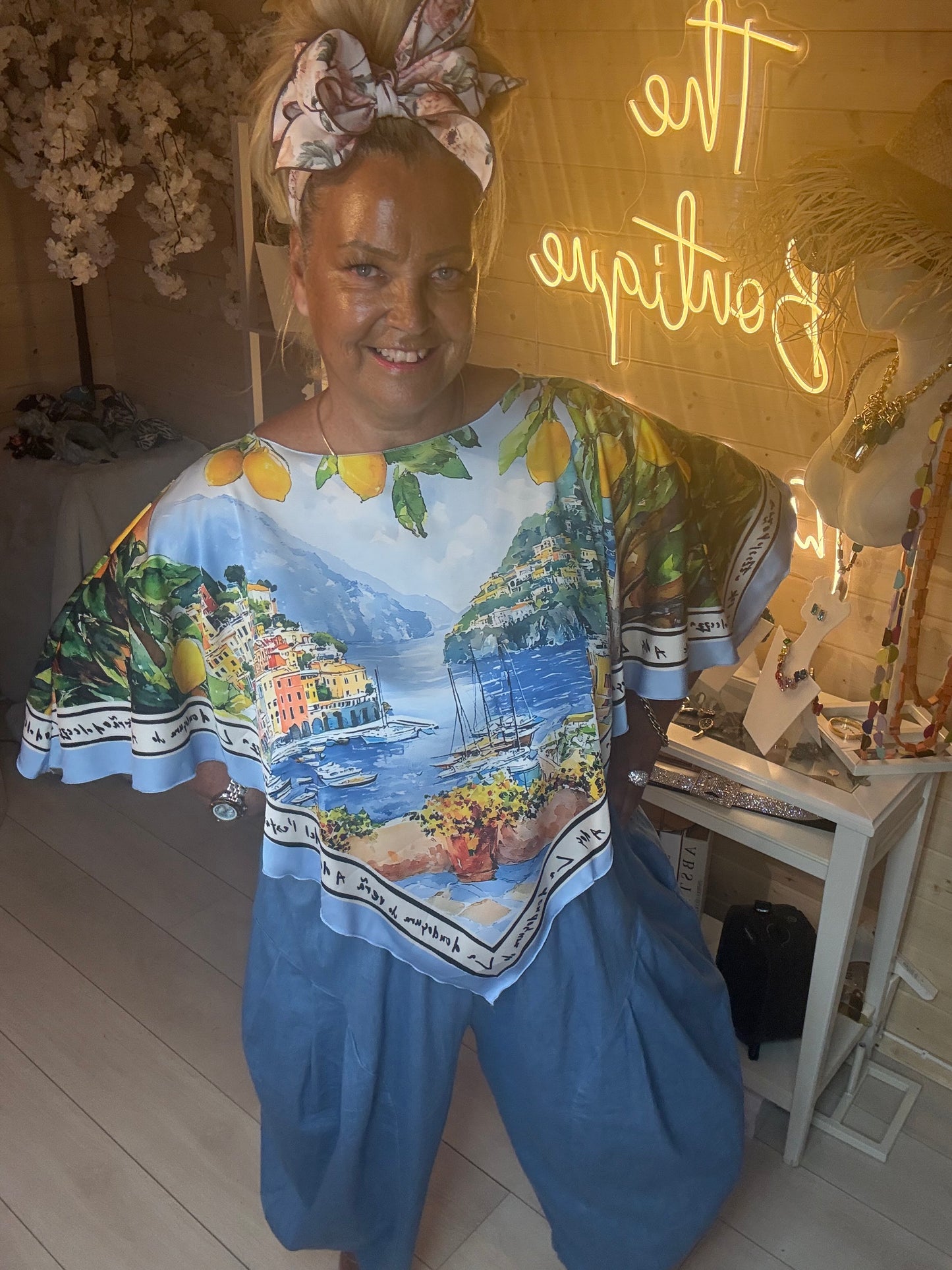 Smiling model wearing Amalfi Poncho Top showing the vibrant Italian print and relaxed fit one size 8-18