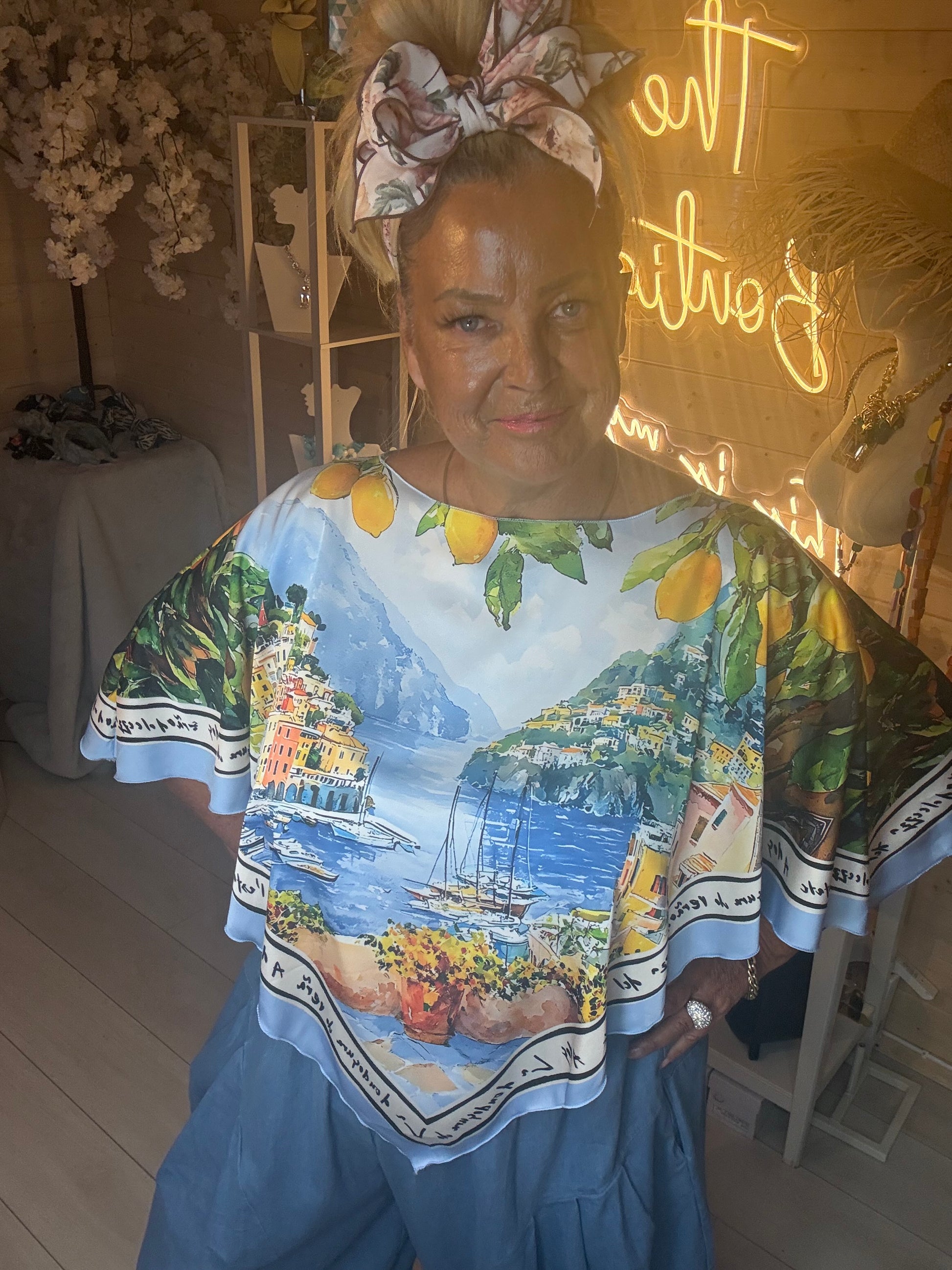 Close up of Amalfi Poncho Top showing detailed Italian coastline scenic print with lemon border