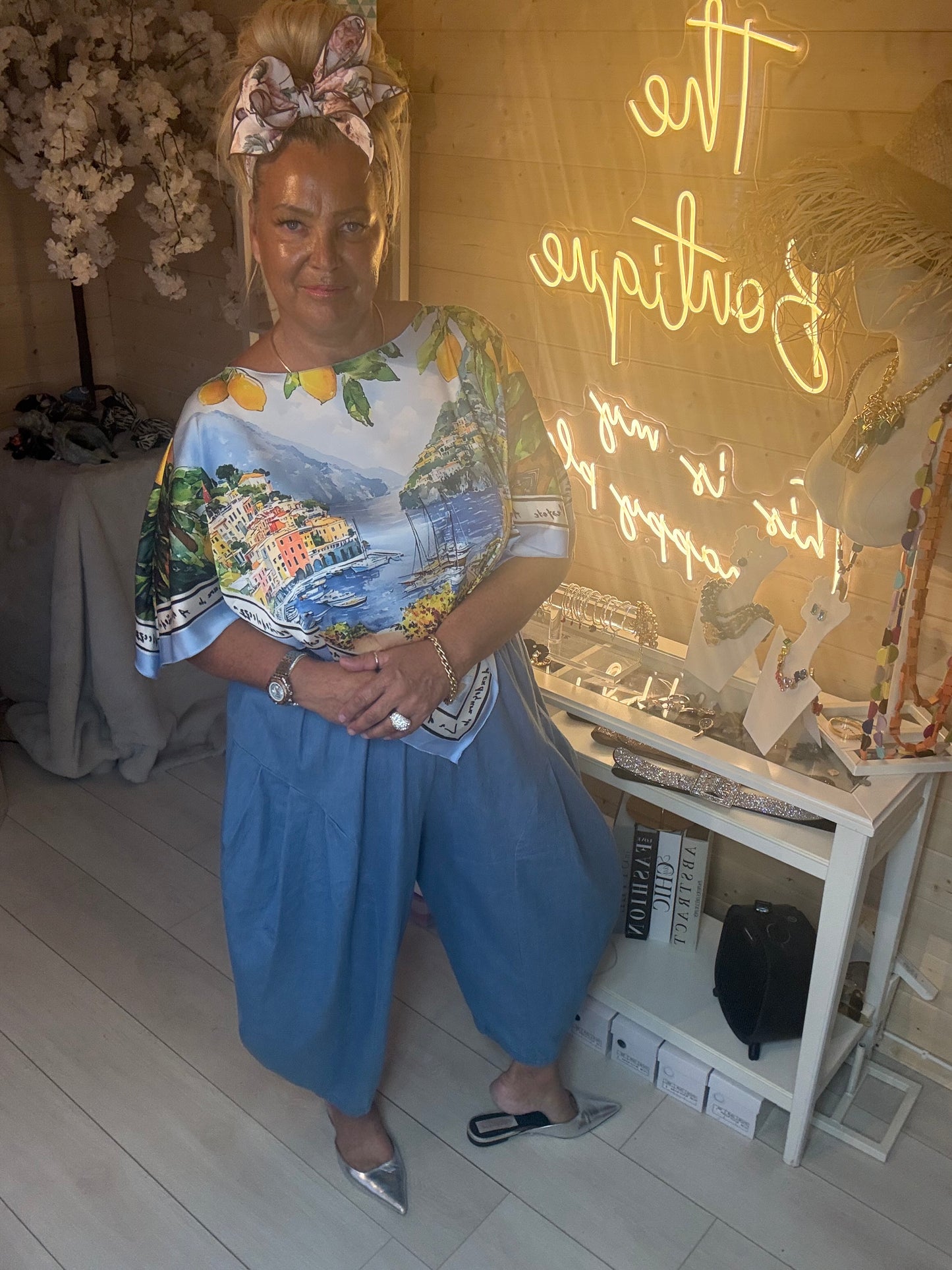 Amalfi Poncho Top styled with plain light denim trousers and silver pointed heels boutique setting
