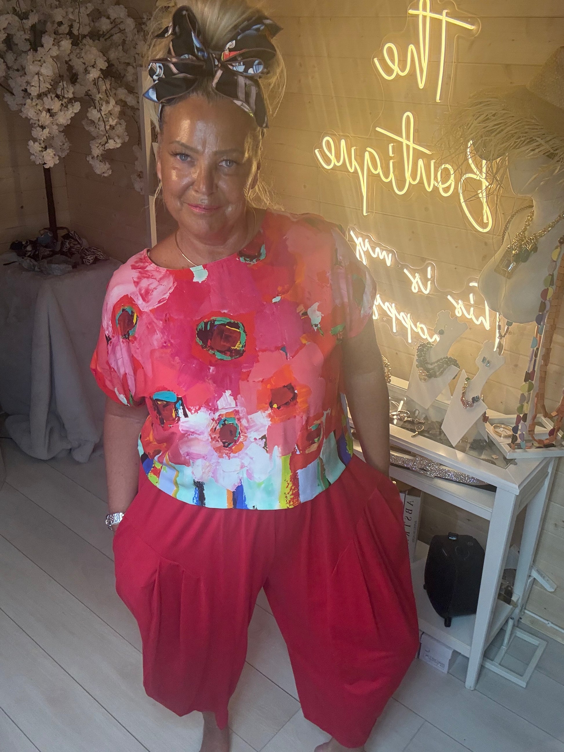 Side angle view of Sorento Coral Abstract Floral Poncho Top showing vibrant abstract floral print detail and relaxed fit