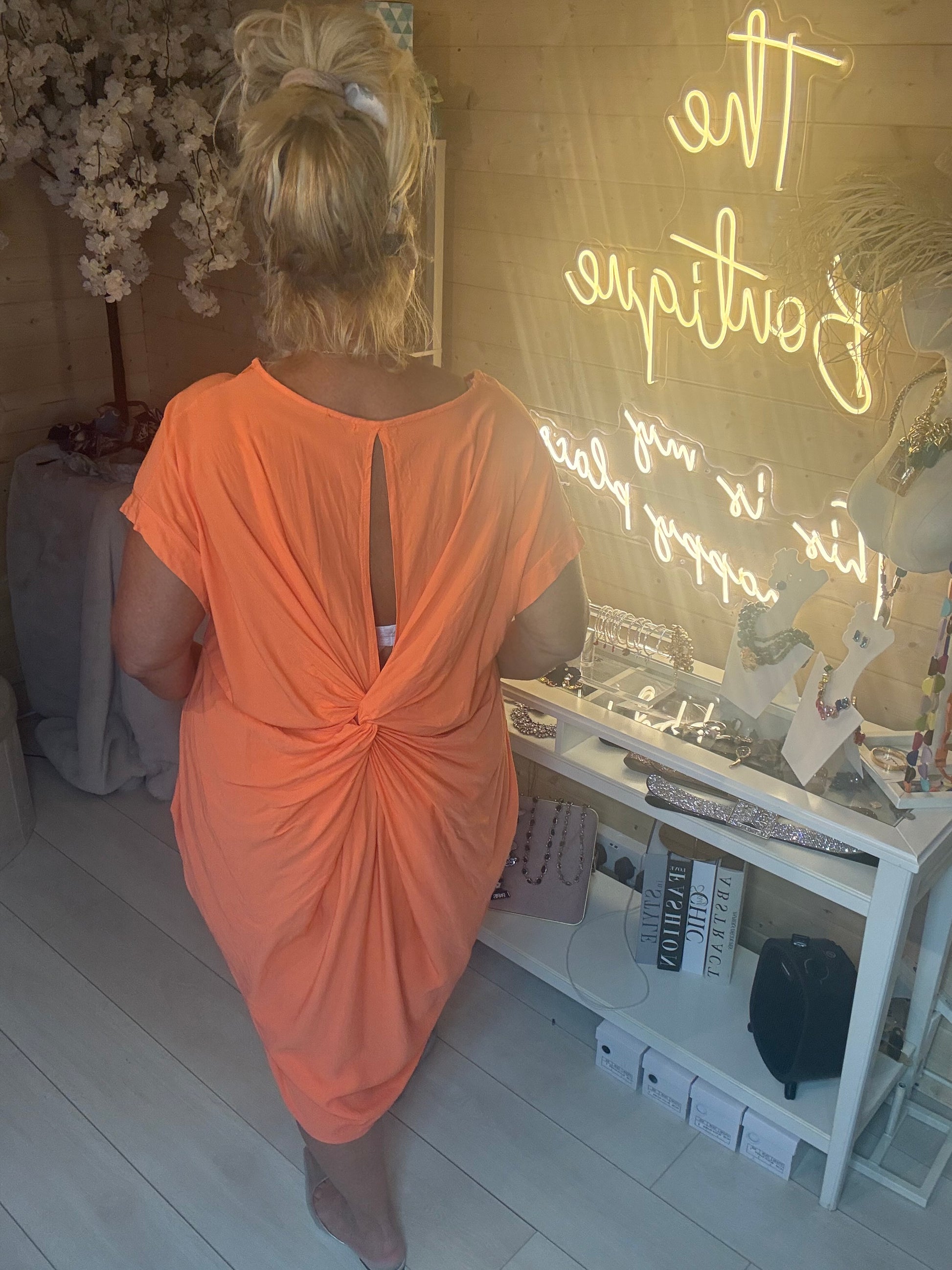Back view of Coral Cocoon Twist Back Jersey Dress showing stunning open twist-knot keyhole back detail in coral orange jersey