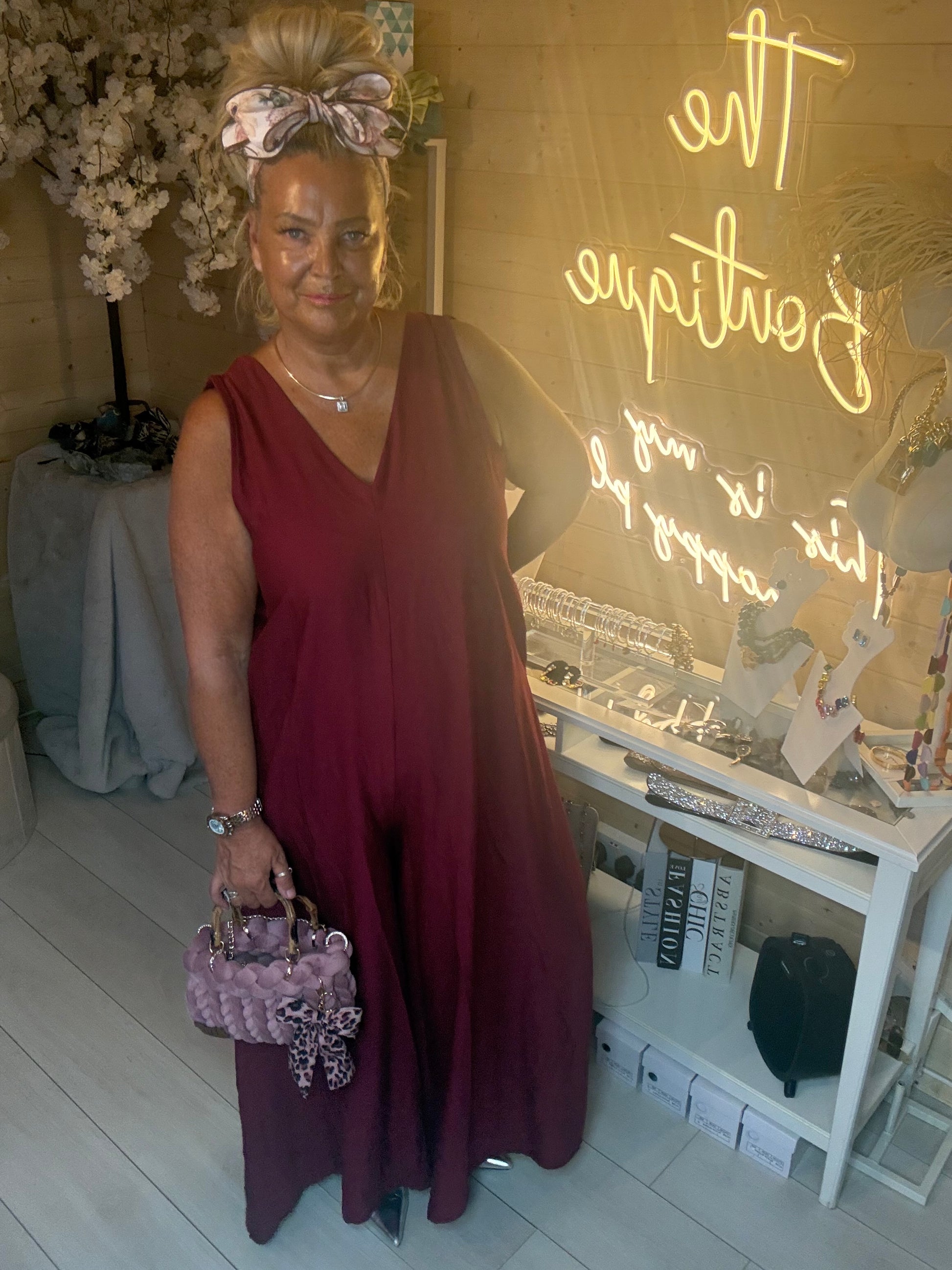 Woman wearing Merlot Burgundy Sleeveless V-Neck Jumpsuit with Lavinia Chunky Woven Tote Bag in lilac with leopard bow in The Ultimate Ladies Boutique