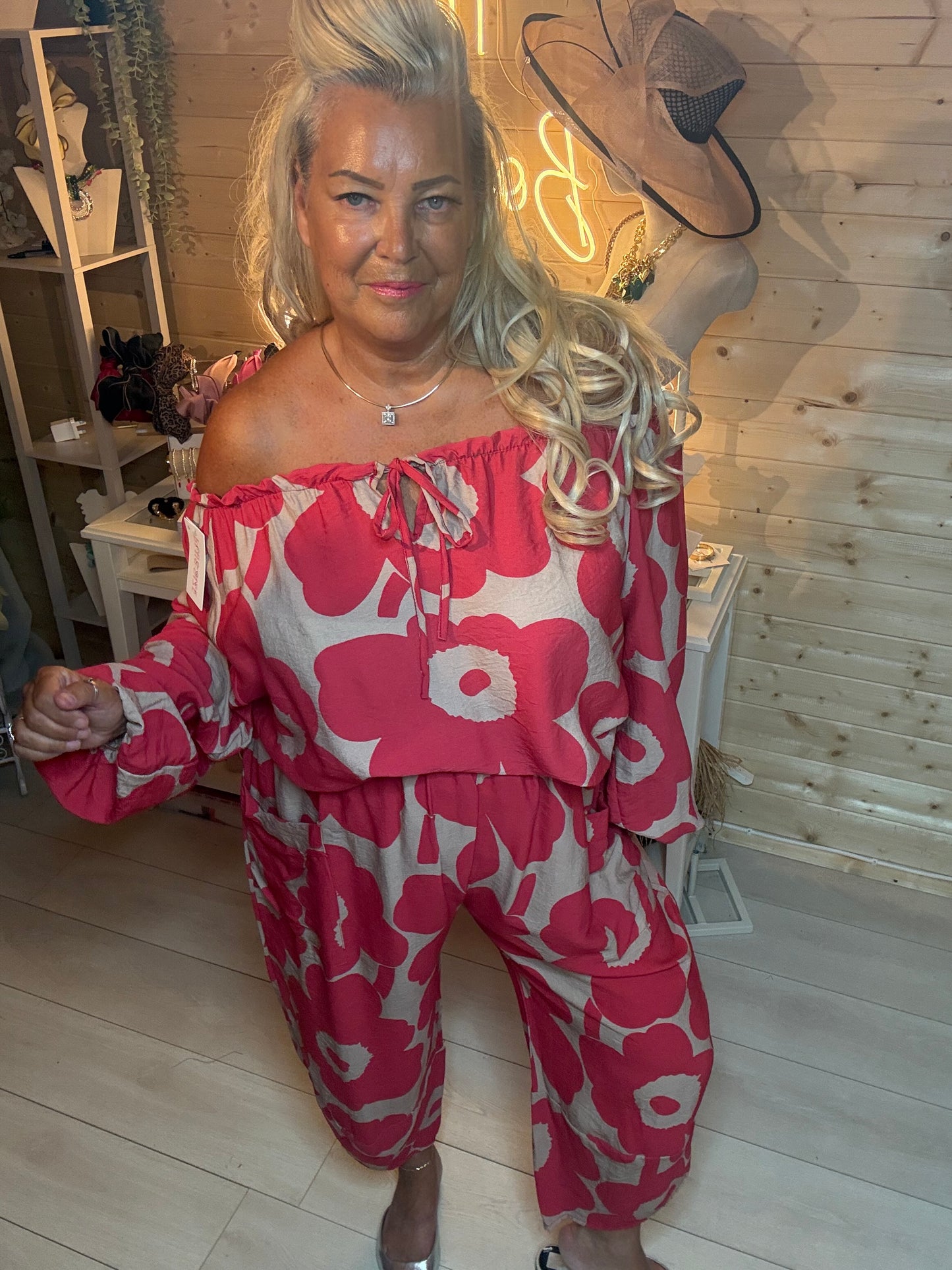 Red floral oversized pocket trousers – styled with silver mules, boutique setting