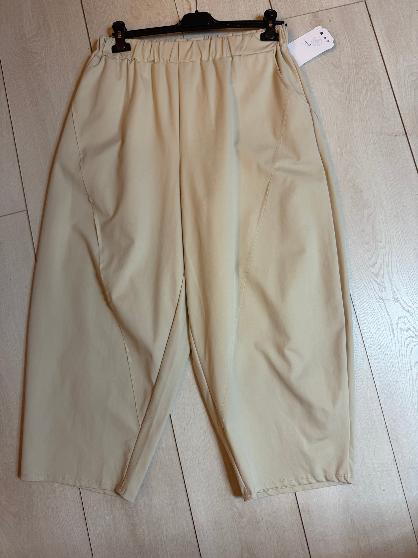 Stone beige cropped culotte trousers flat lay on hanger showing elasticated waist and wide-leg silhouette