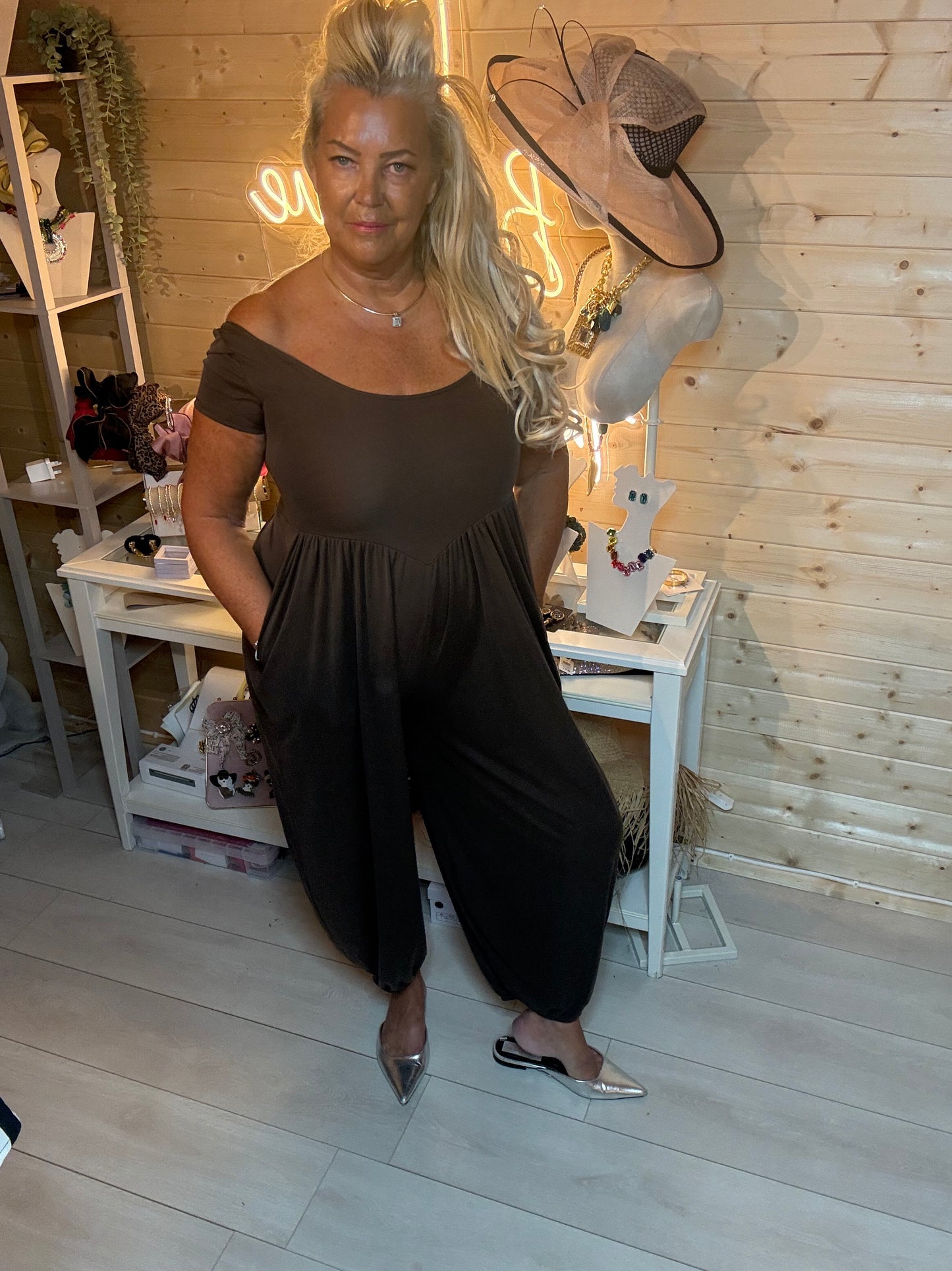 Black harem jumpsuit worn off the shoulder – showing gathered empire waist and relaxed tapered harem legs