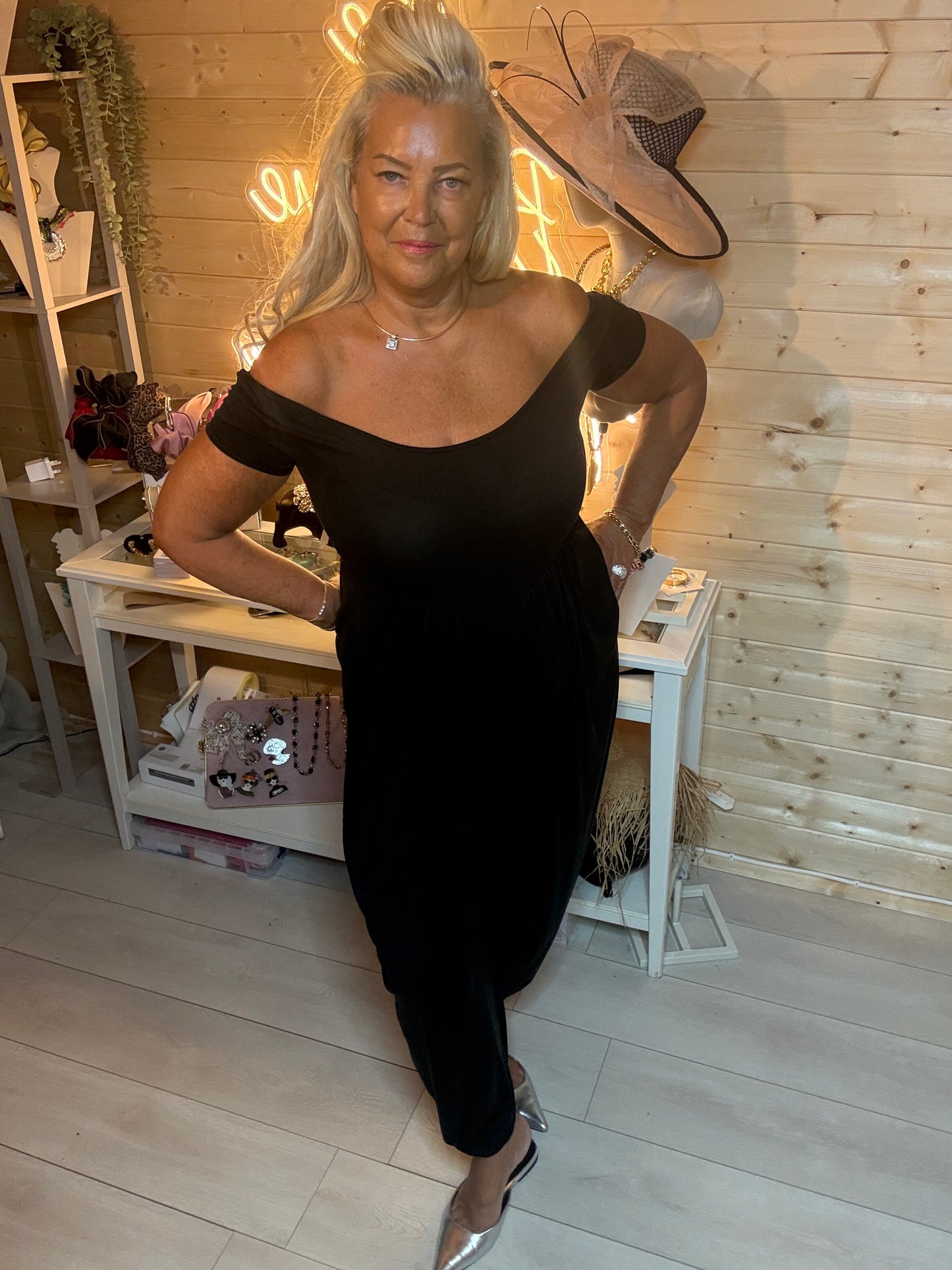 Black harem jumpsuit – close up showing gathered waist, deep side pocket and tapered leg detail with silver mules