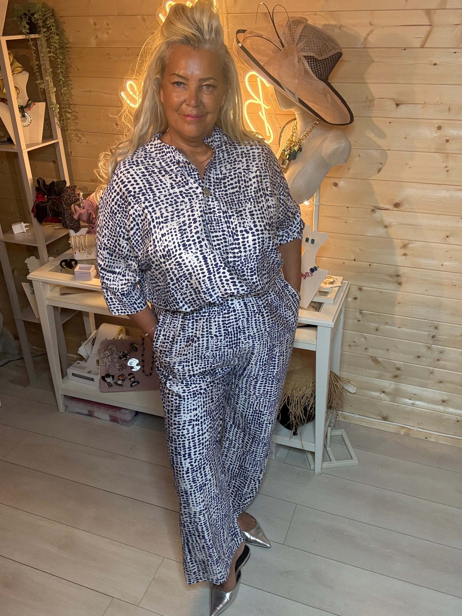 Navy and white abstract spot print co-ord set – full length front view showing oversized shirt and wide-leg trousers styled with silver mules, boutique setting