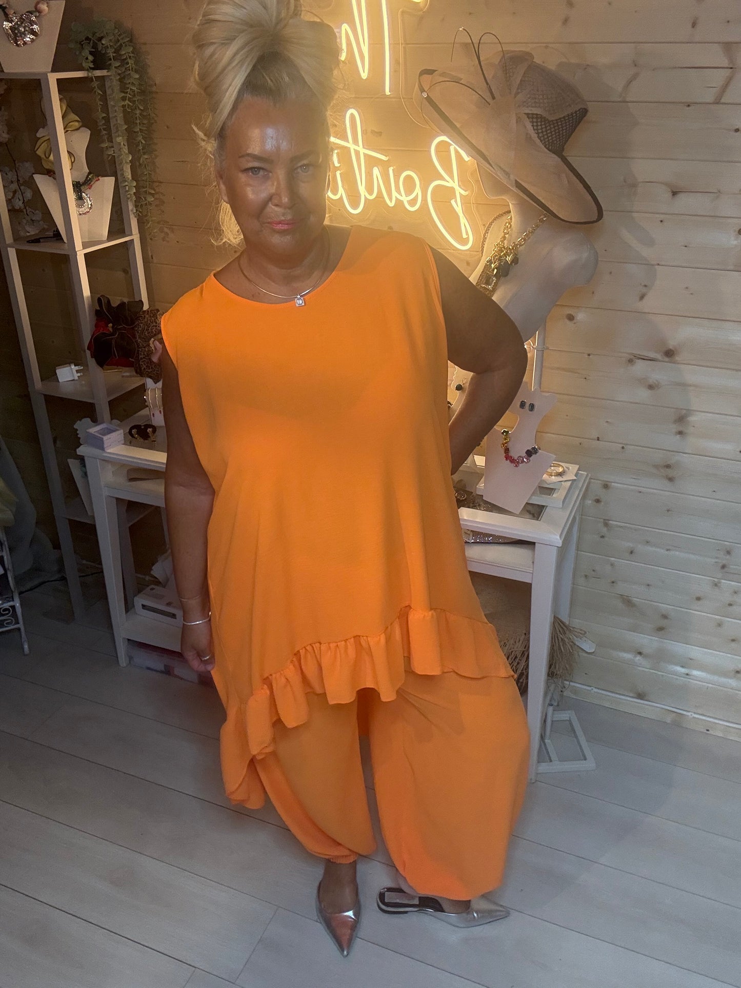 Orange sleeveless ruffle hem co-ord set – full length front view showing oversized vest top, asymmetric hem and relaxed harem trousers