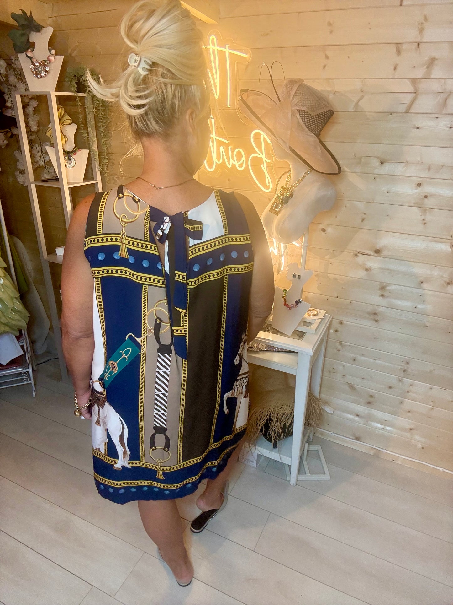 Navy equestrian print shift dress – three quarter length boutique shot showing gold chain border hem and full scarf-print silhouette with silver mules