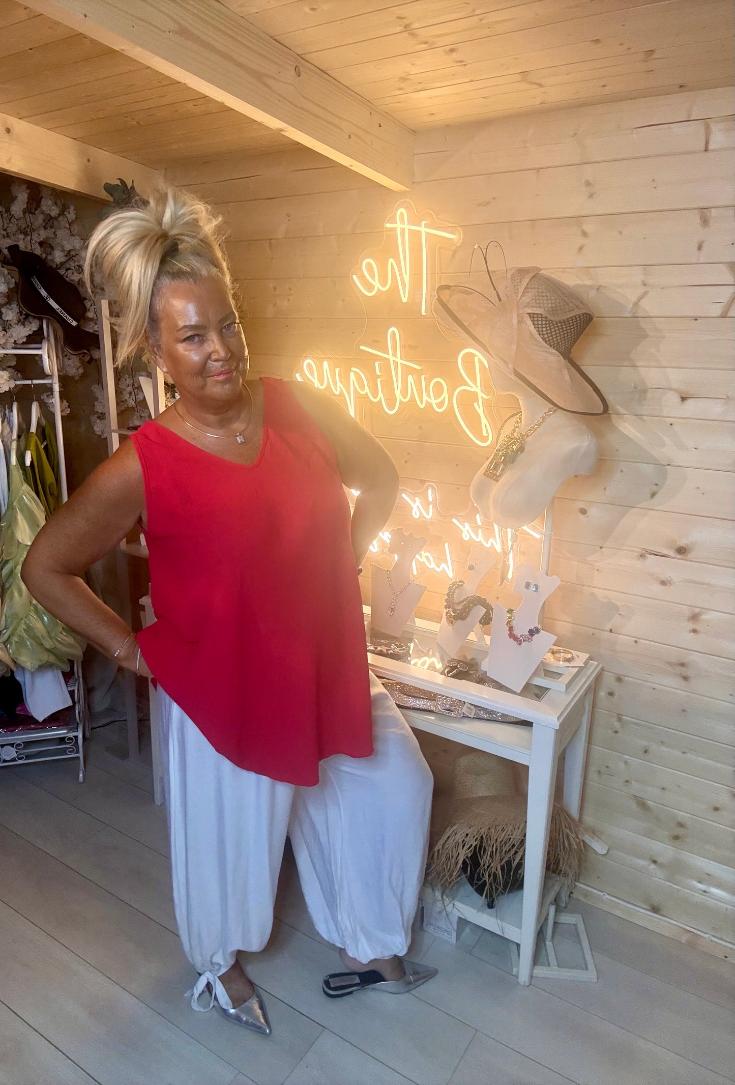 White tie cuff harem trousers – full length boutique shot showing relaxed wide-leg silhouette with ankle tie cuff styled with red sleeveless asymmetric top and silver mules