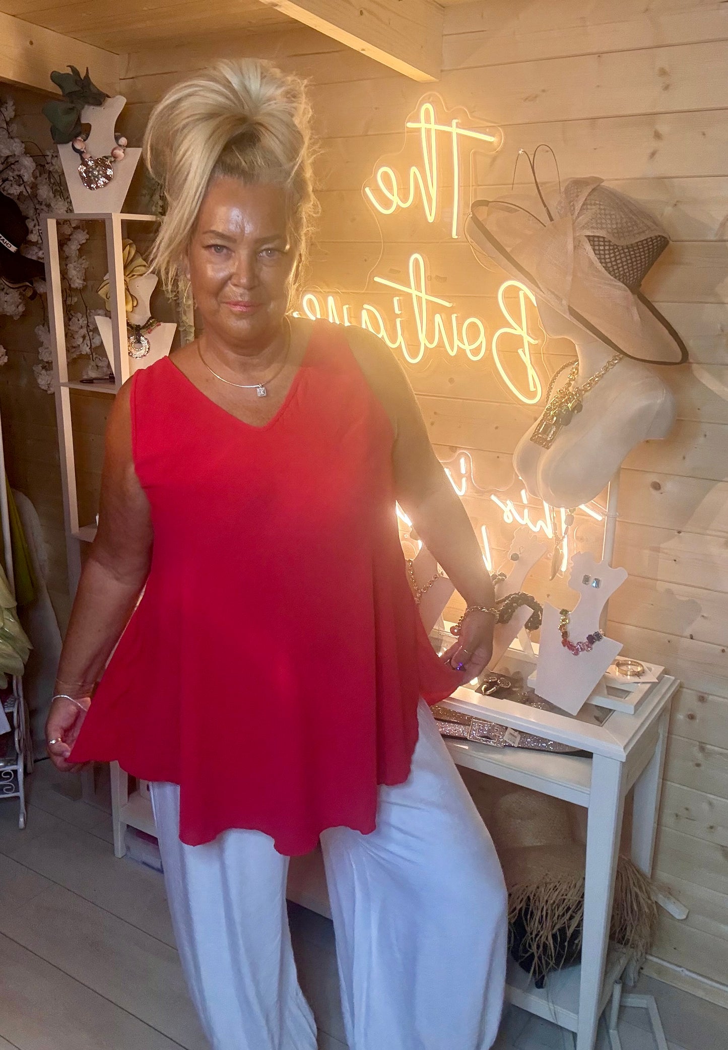 Red V-neck swing vest top – full length front view showing bold red colourway, deep V-neckline and flowy swing silhouette with white wide-leg trousers