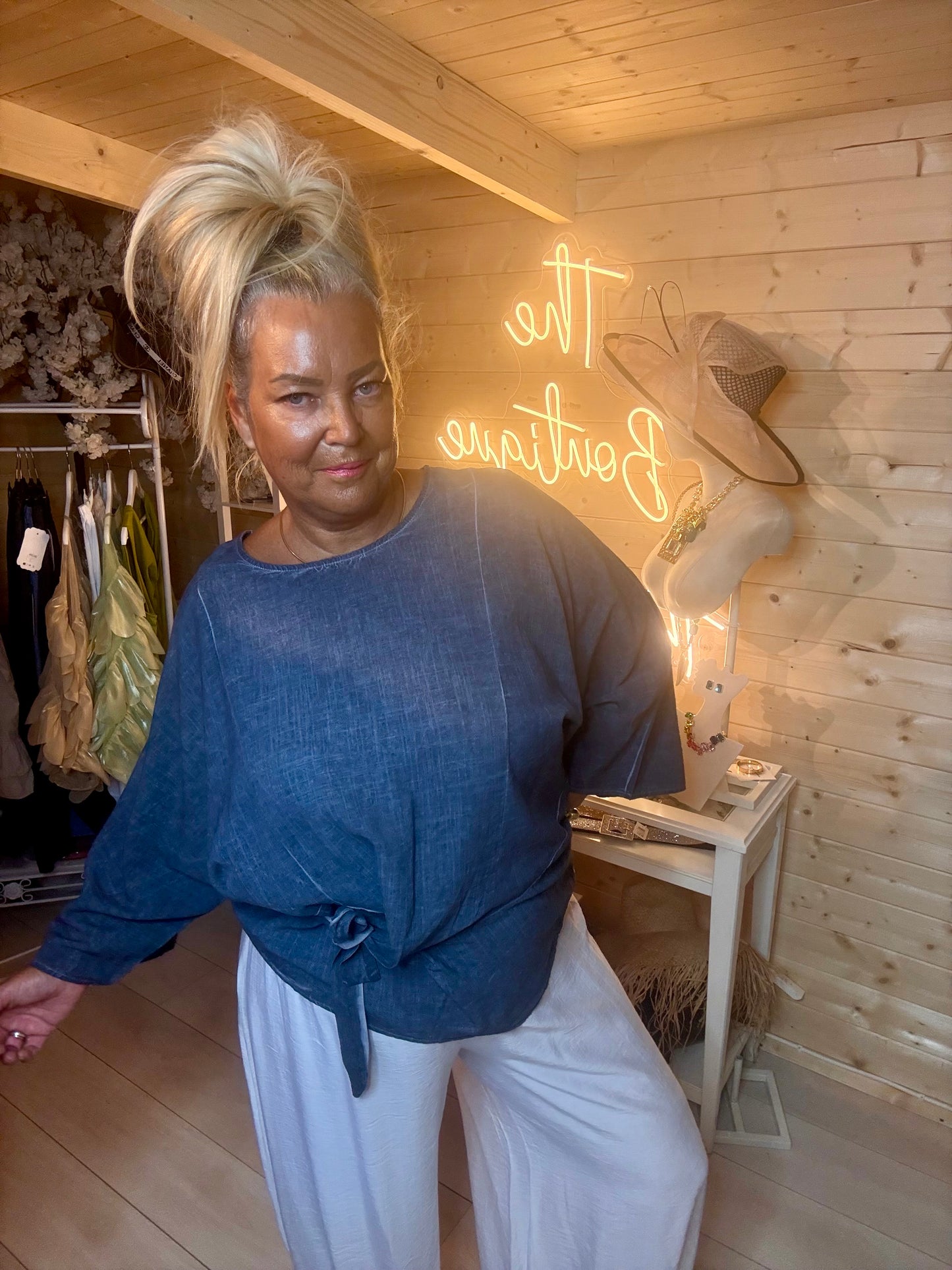 Charcoal wrap tie top – three quarter length boutique shot showing relaxed batwing silhouette and front wrap tie waist detail with white trousers