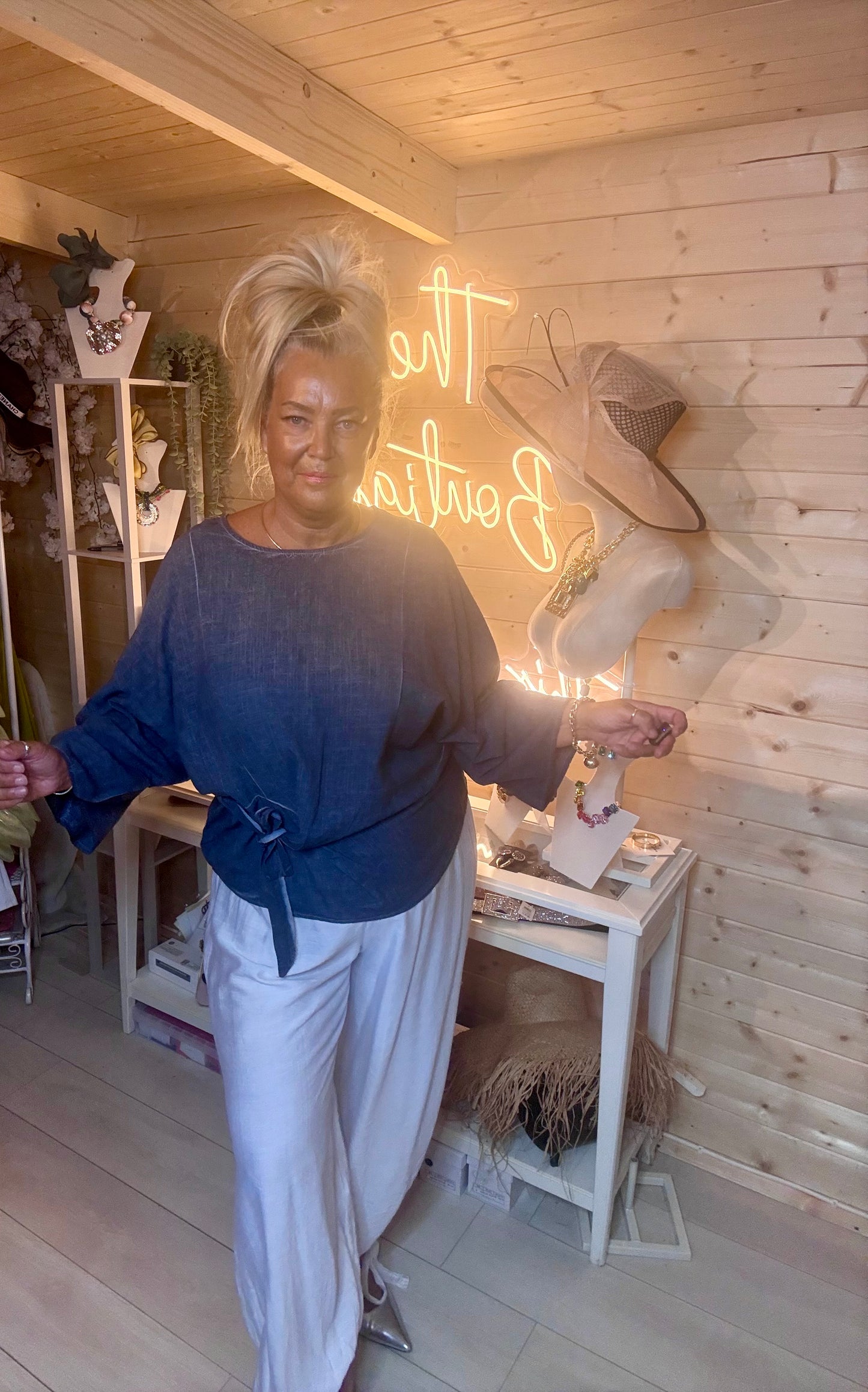 Charcoal linen-look batwing top – full length side view showing wrap tie waist detail and relaxed batwing sleeve silhouette styled with white wide-leg trousers and silver mules