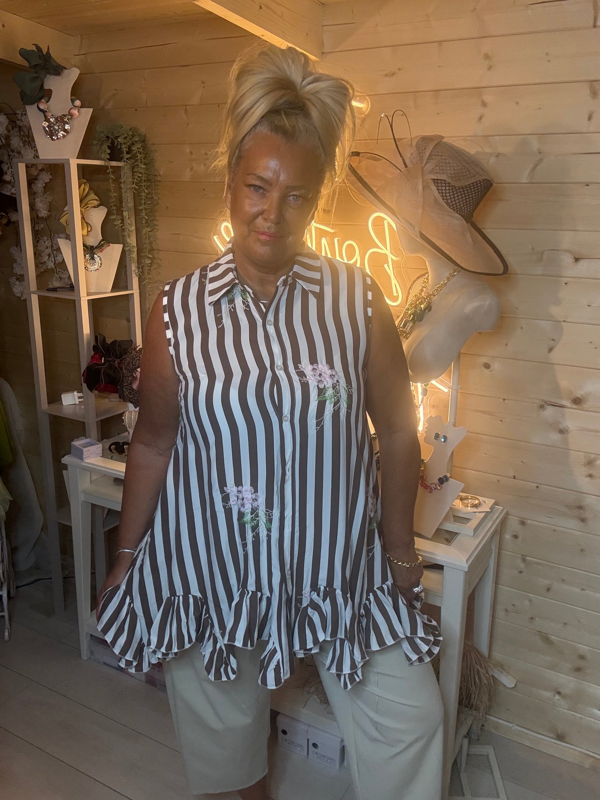 Navy stripe shirt tunic – full length three quarter view showing floaty double ruffle hem and floral embroidery detail with white trousers and silver mules
