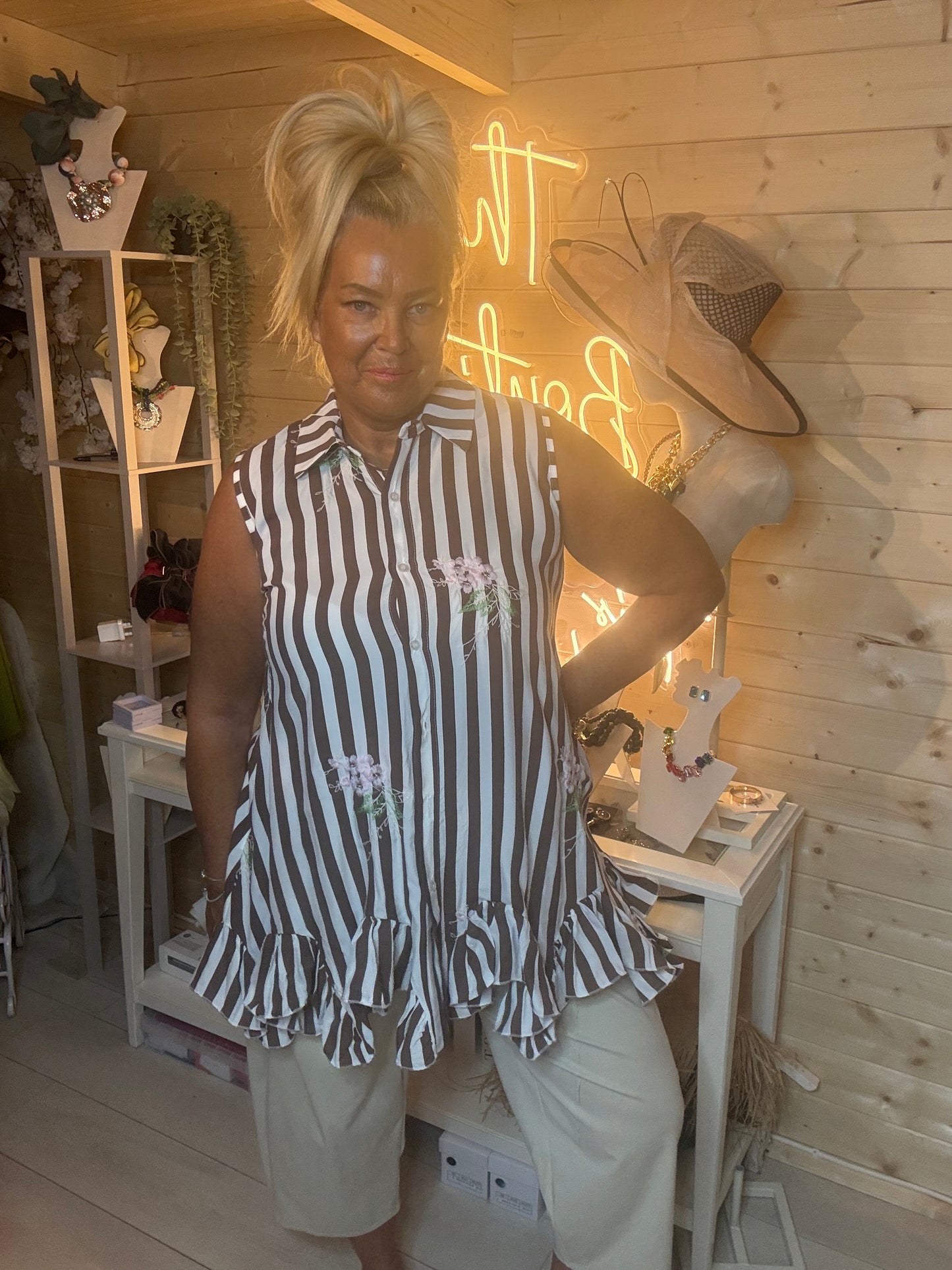 Navy stripe shirt tunic – full length front view showing relaxed silhouette, double ruffle peplum hem and floral embroidery styled with stone shorts in boutique setting