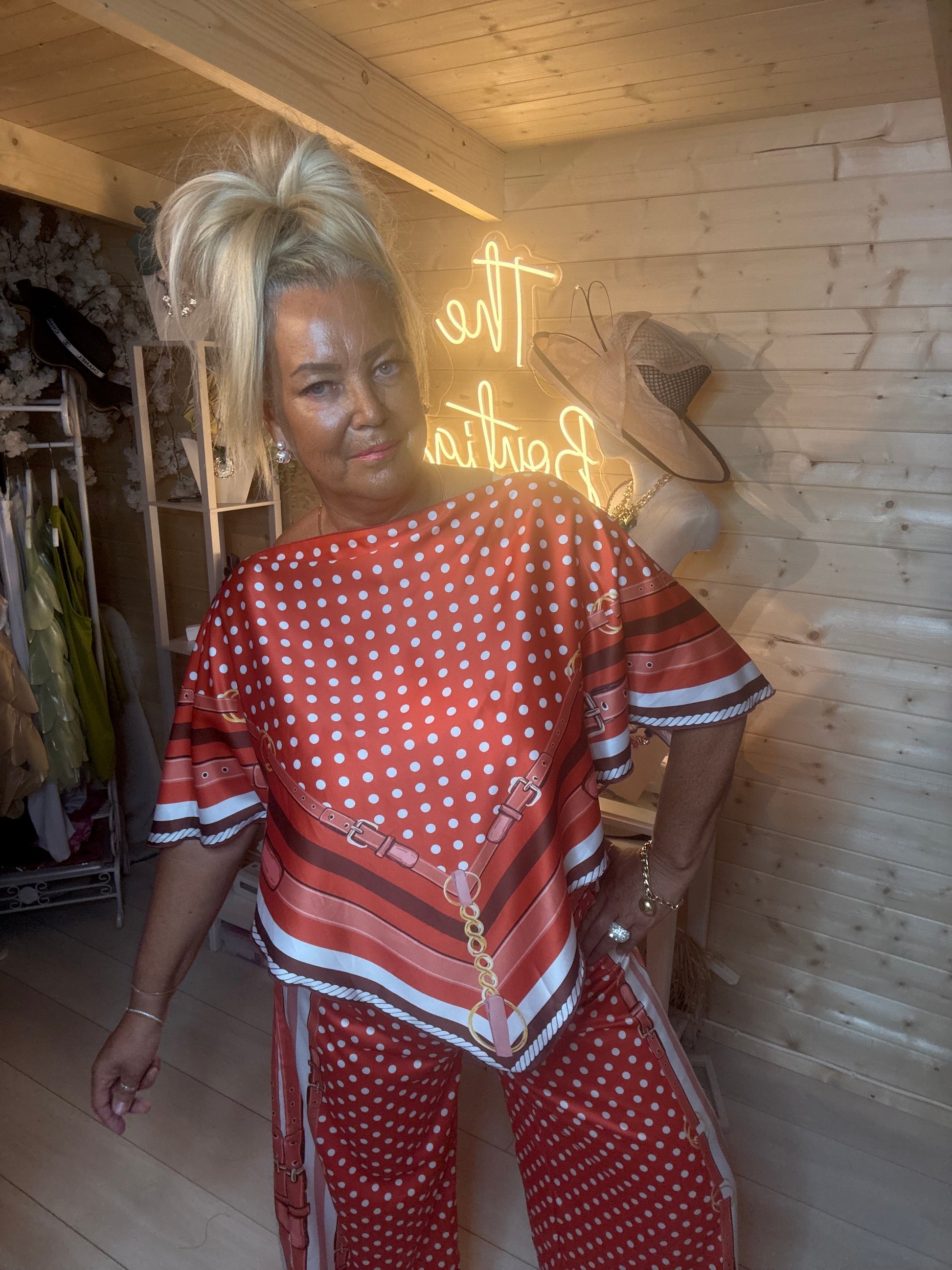 Rust polka dot scarf print co-ord – full length boutique shot showing relaxed batwing silhouette and wide-leg trousers with stripe border hem styled with silver mules